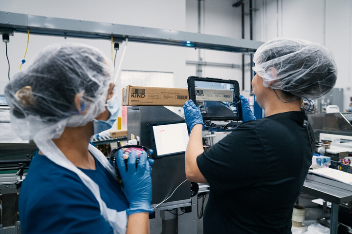 KIND employees doing a quality check using an iPad