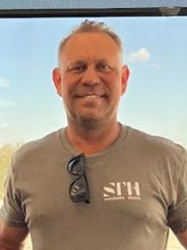 Man smiling wearing a company shirt