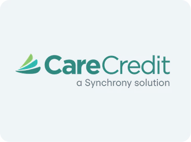 Close-up of a person holding a dental model and pointing to teeth with a dental tool.