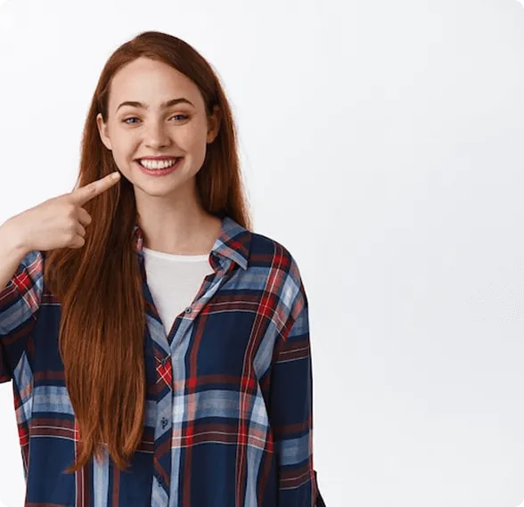 Modern dental examination room with a black and white dental chair, dental equipment, a large mirror on gray wall, and a mounted TV screen.