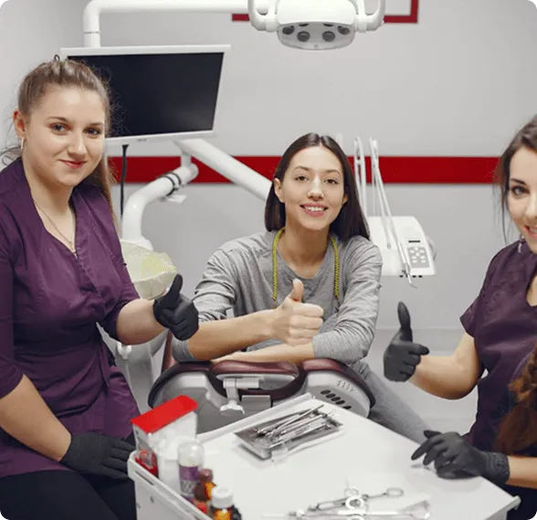 Dentist holding a dental shade guide near a smiling woman's teeth to match tooth color.