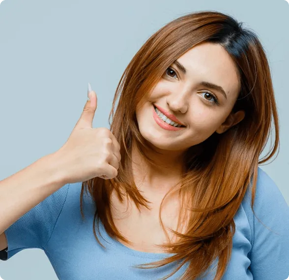 Dentist holding a dental shade guide near a smiling woman's teeth to match tooth color.