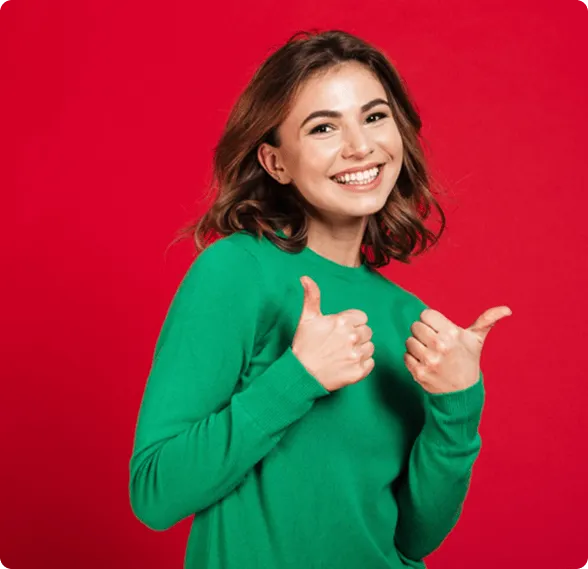 Smiling man sitting in a dental chair giving a thumbs-up in a bright dental office.