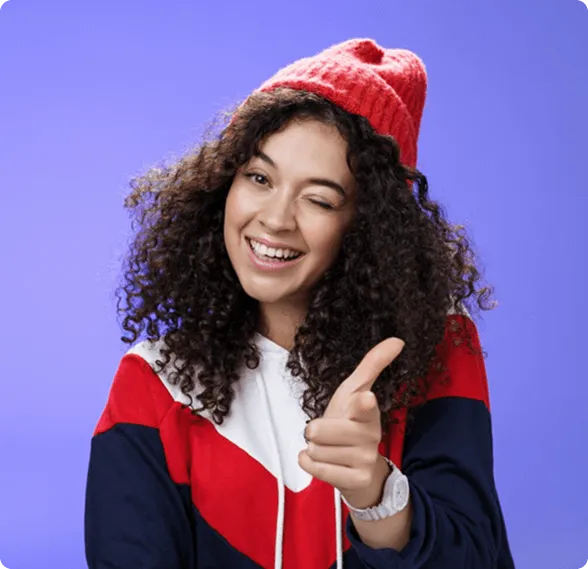 Dentist holding a dental shade guide near a smiling woman's teeth to match tooth color.