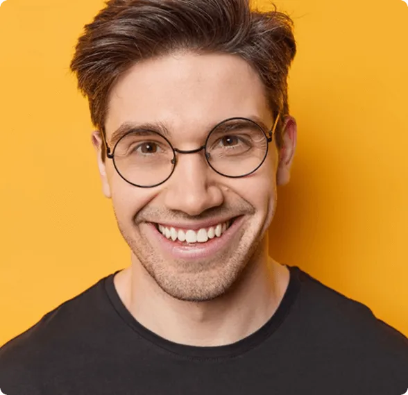 Dentist holding a dental shade guide near a smiling woman's teeth to match tooth color.