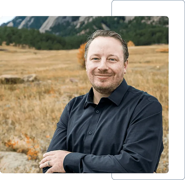 Dentist holding a dental shade guide near a smiling woman's teeth to match tooth color.