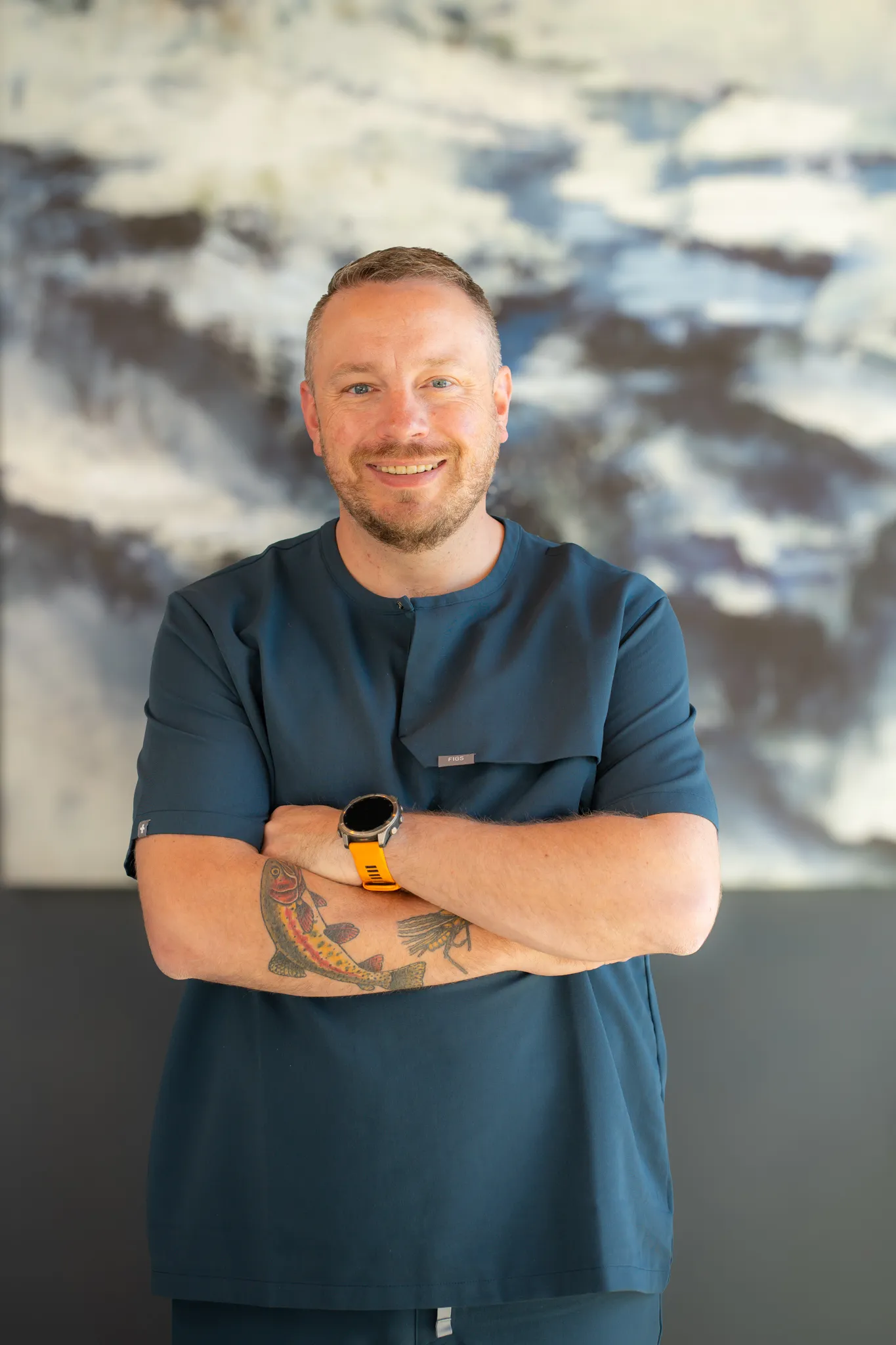 Smiling man sitting in a dental chair giving a thumbs-up in a bright dental office.