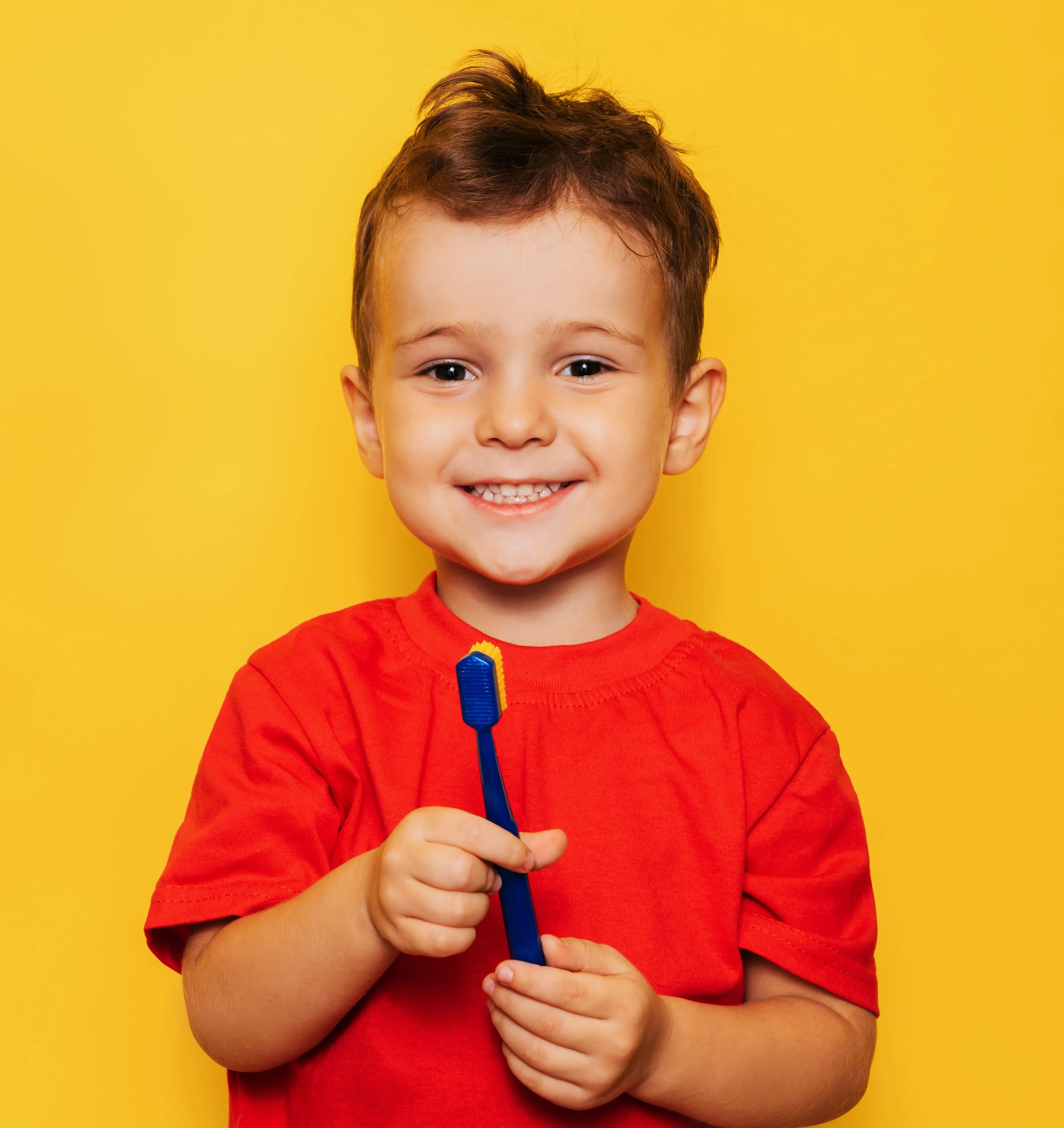 Smiling woman reclined in a dental chair, interacting with a dentist wearing blue gloves.