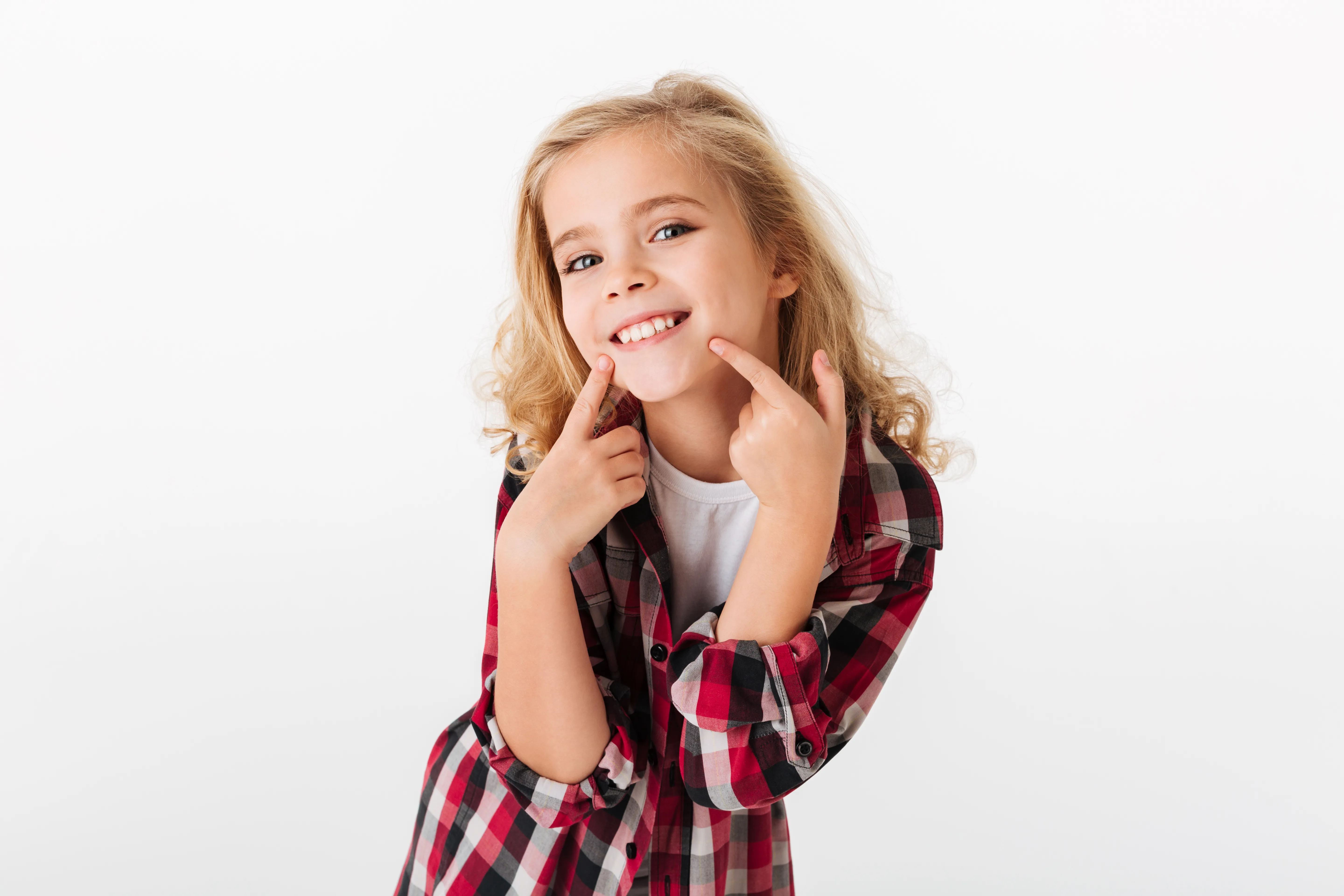 Modern dental examination room with a black and white dental chair, dental equipment, a large mirror on gray wall, and a mounted TV screen.