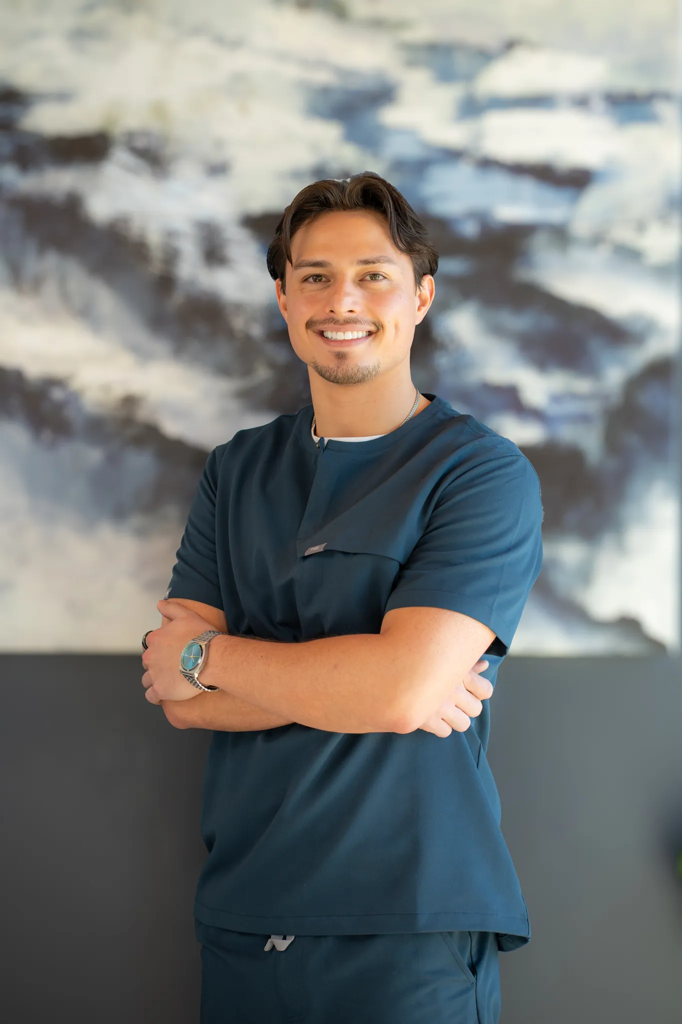 Dentist holding a dental shade guide near a smiling woman's teeth to match tooth color.
