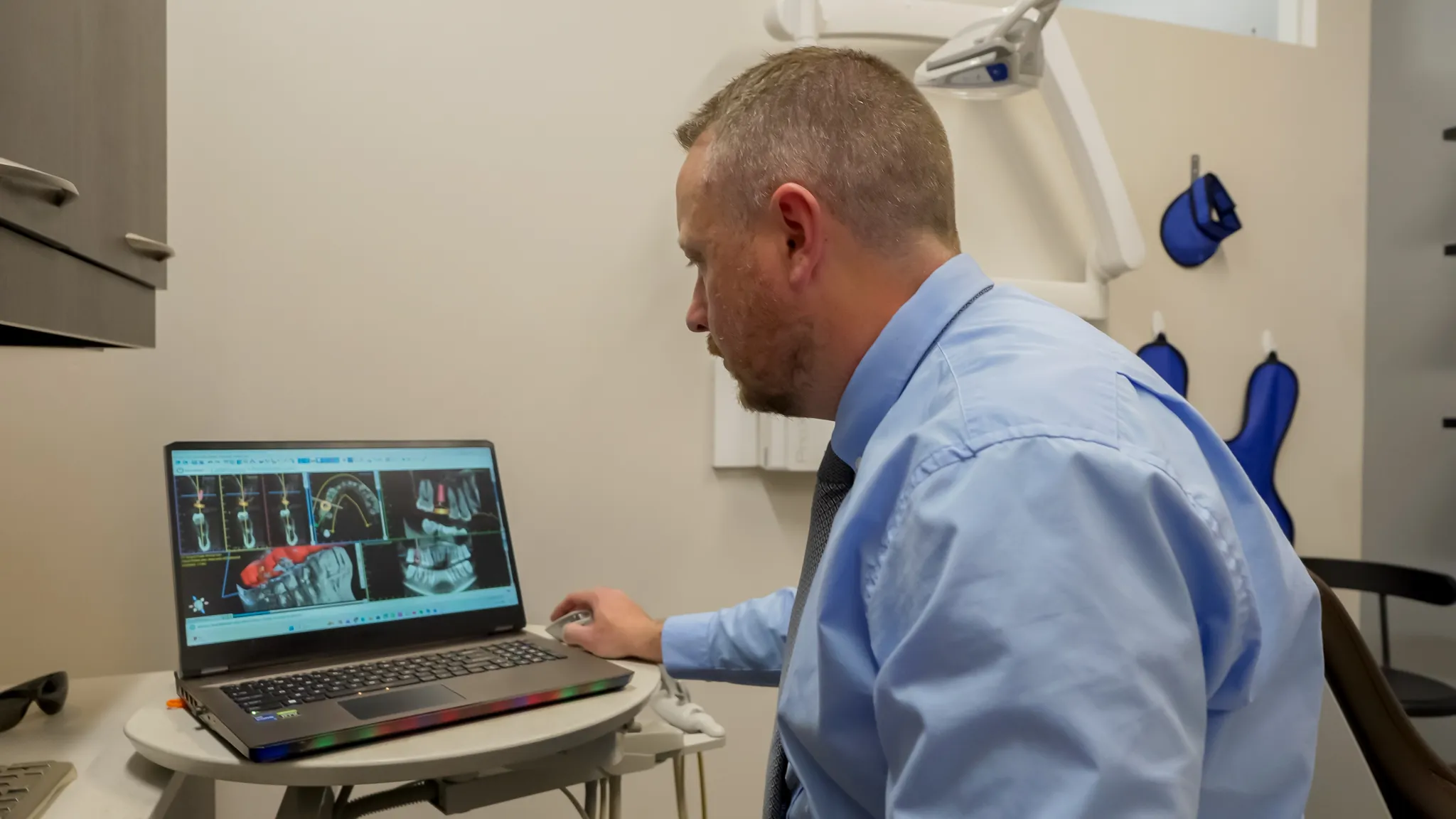 Smiling woman sitting in a dental chair giving a thumbs-up with a dental bib.