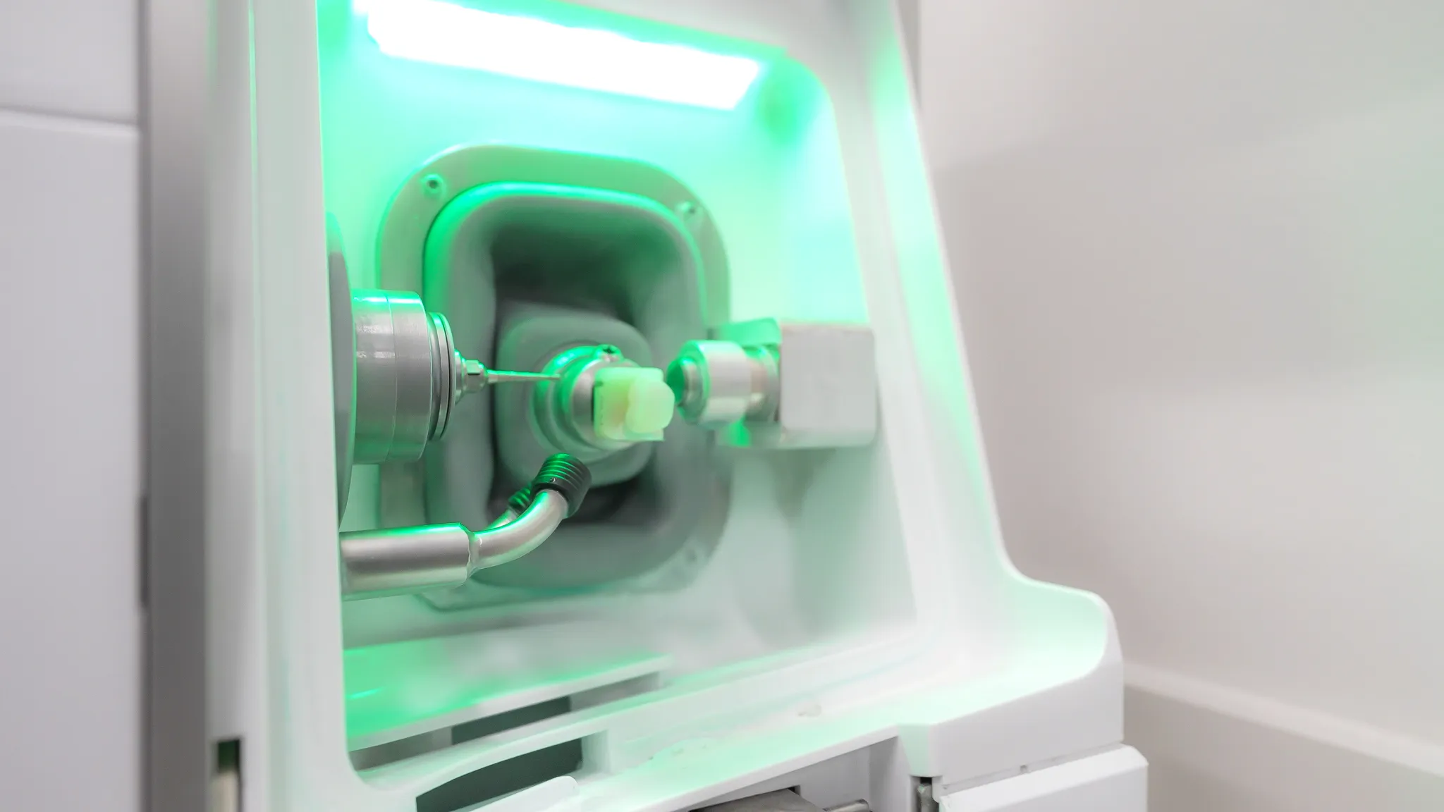 Dentist holding a dental shade guide near a smiling woman's teeth to match tooth color.