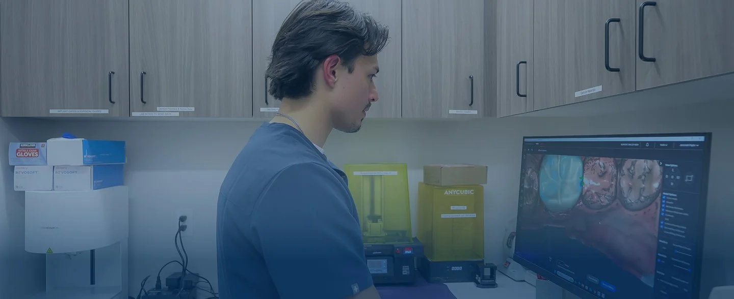 Modern reception desk with marble countertop, two computer monitors, pendant lights, and large windows showing exterior building.