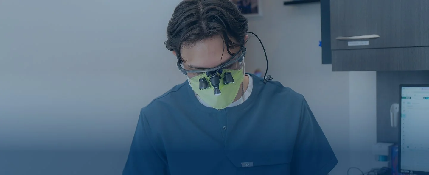 Modern reception desk with marble countertop, two computer monitors, pendant lights, and large windows showing exterior building.