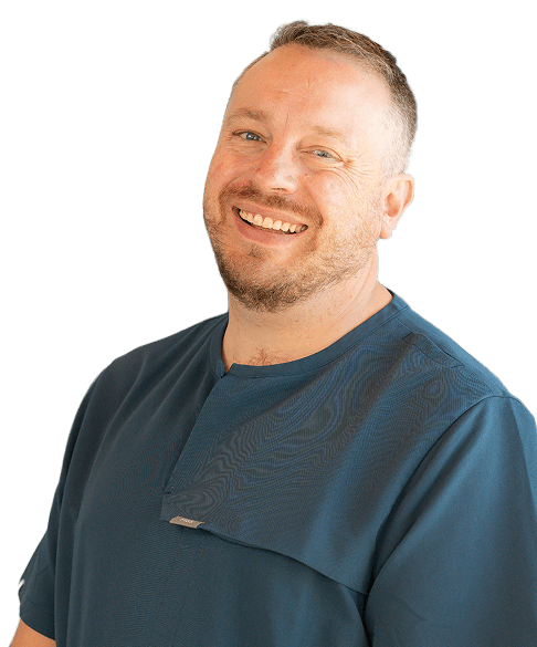 Smiling man with short hair wearing a dark button-up shirt with arms crossed.