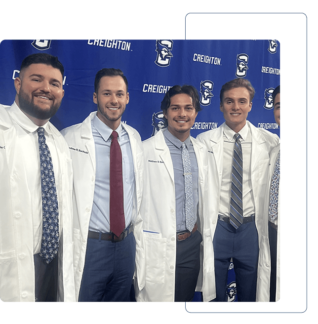 Dentist holding a dental shade guide near a smiling woman's teeth to match tooth color.