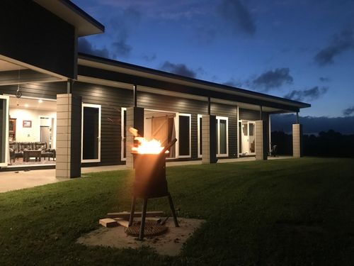 Newly constructed home at night with a firepit blazing
