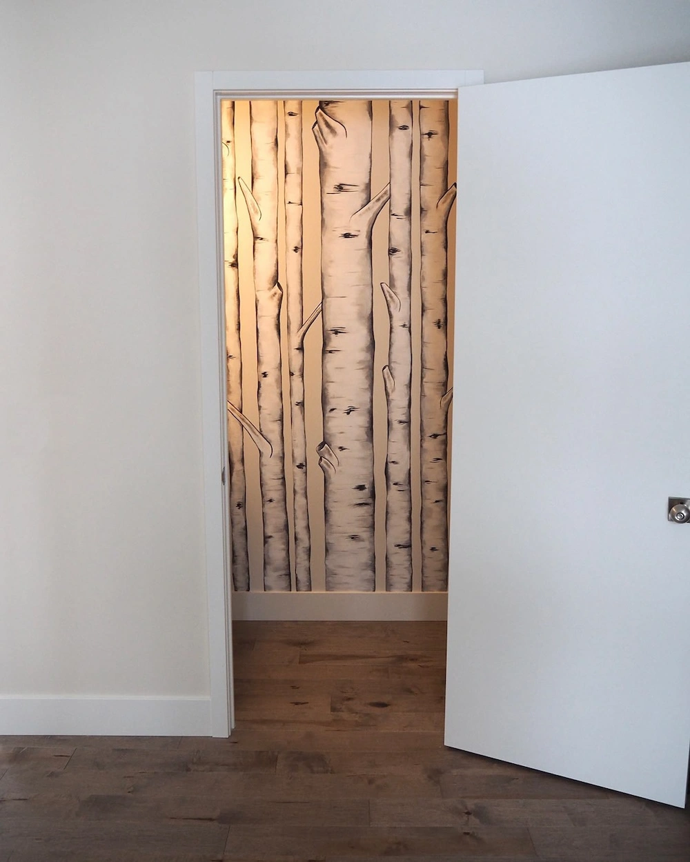 Mural painted inside of a bathroom of birch trees