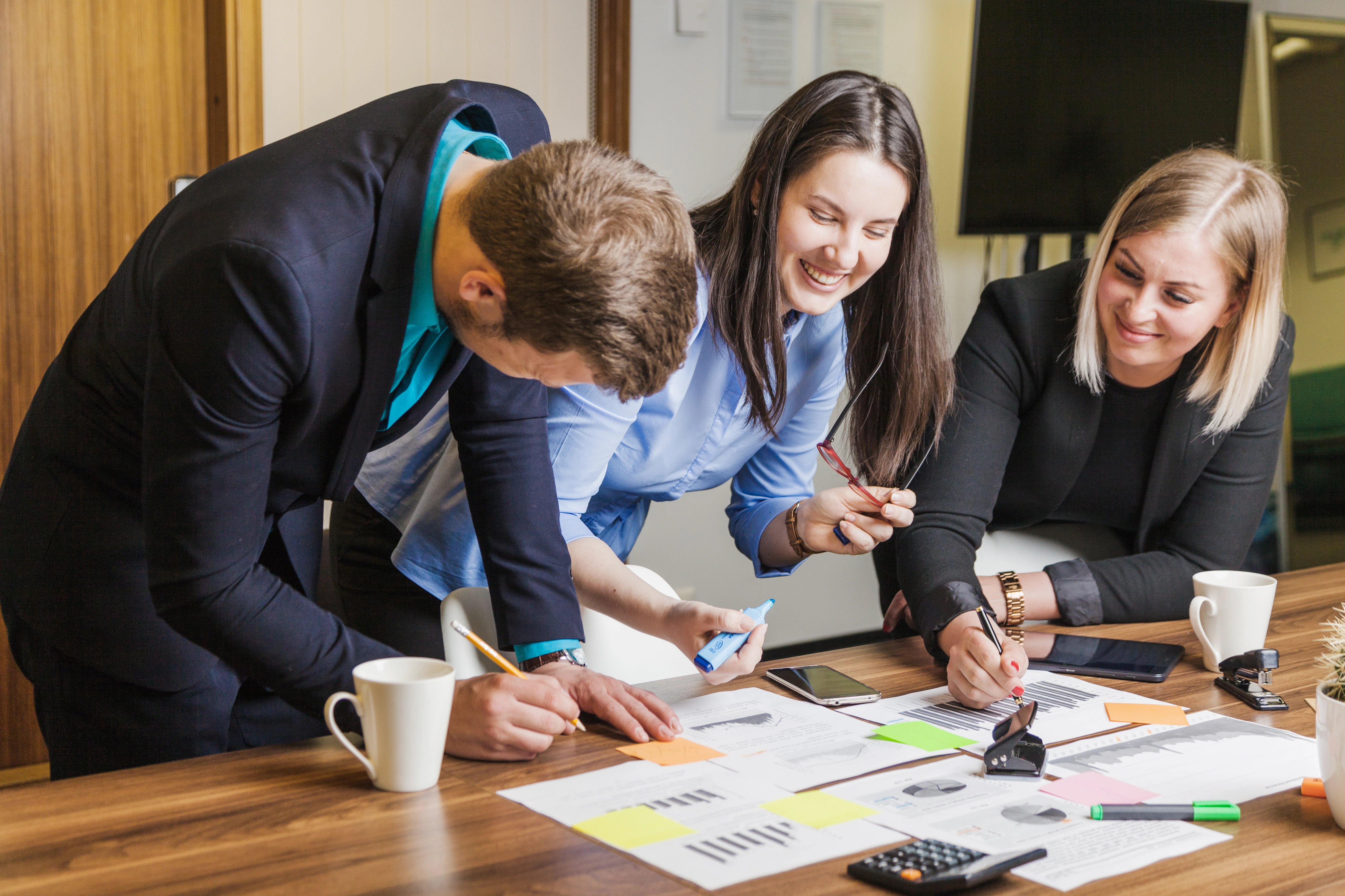 People collaborating at a desk and smiling