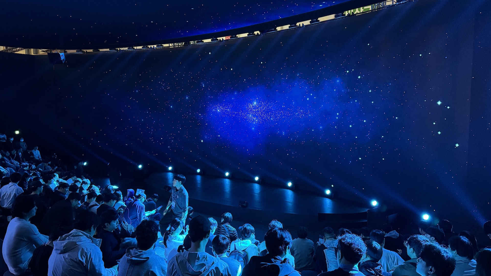 Spherical LED display dome showing cosmic starfield visualization with seated audience experiencing immersive dome LED theater environment