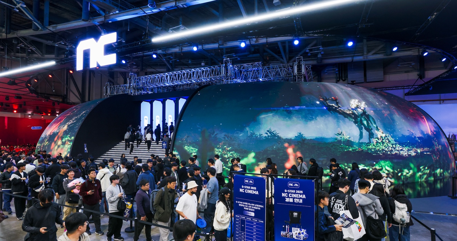Large crowd queuing at the entrance of NC CINEMA dome LED theater at G-STAR 2025, with a curved semi-spherical LED surface displaying a lush fantasy forest scene, exhibition signage visible in the foreground and the NC logo mounted overhead
