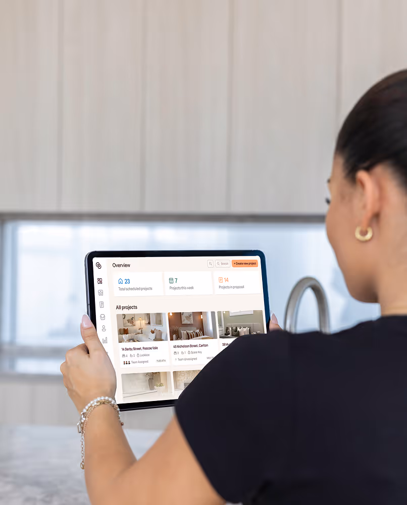 Person holding a tablet displaying a project management overview with scheduled and current projects.