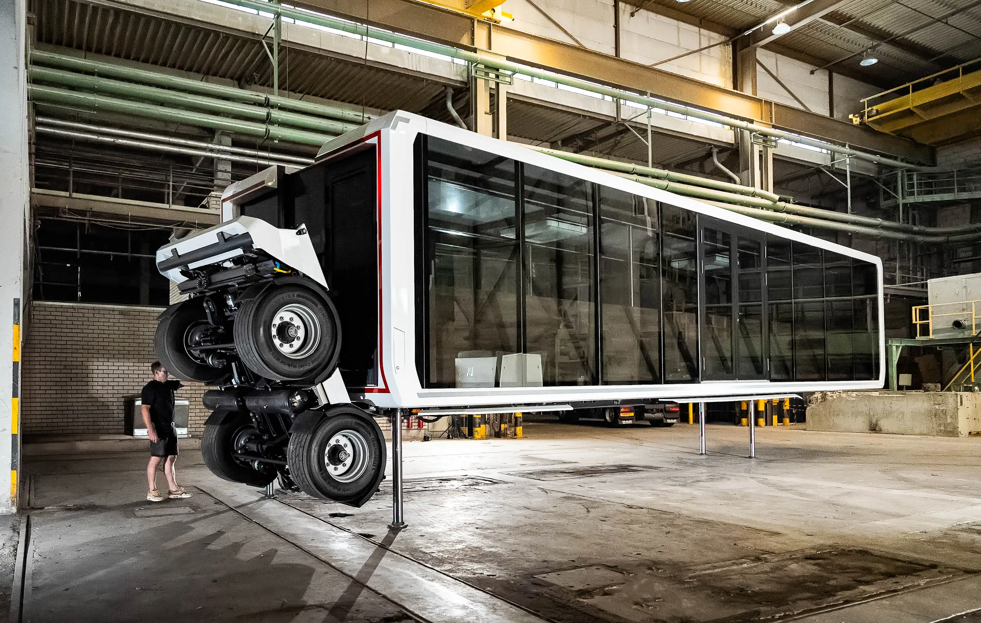Expandable relocatable space lifted on hydraulic legs with transportation wheels folded, showing mobility system inside production hall