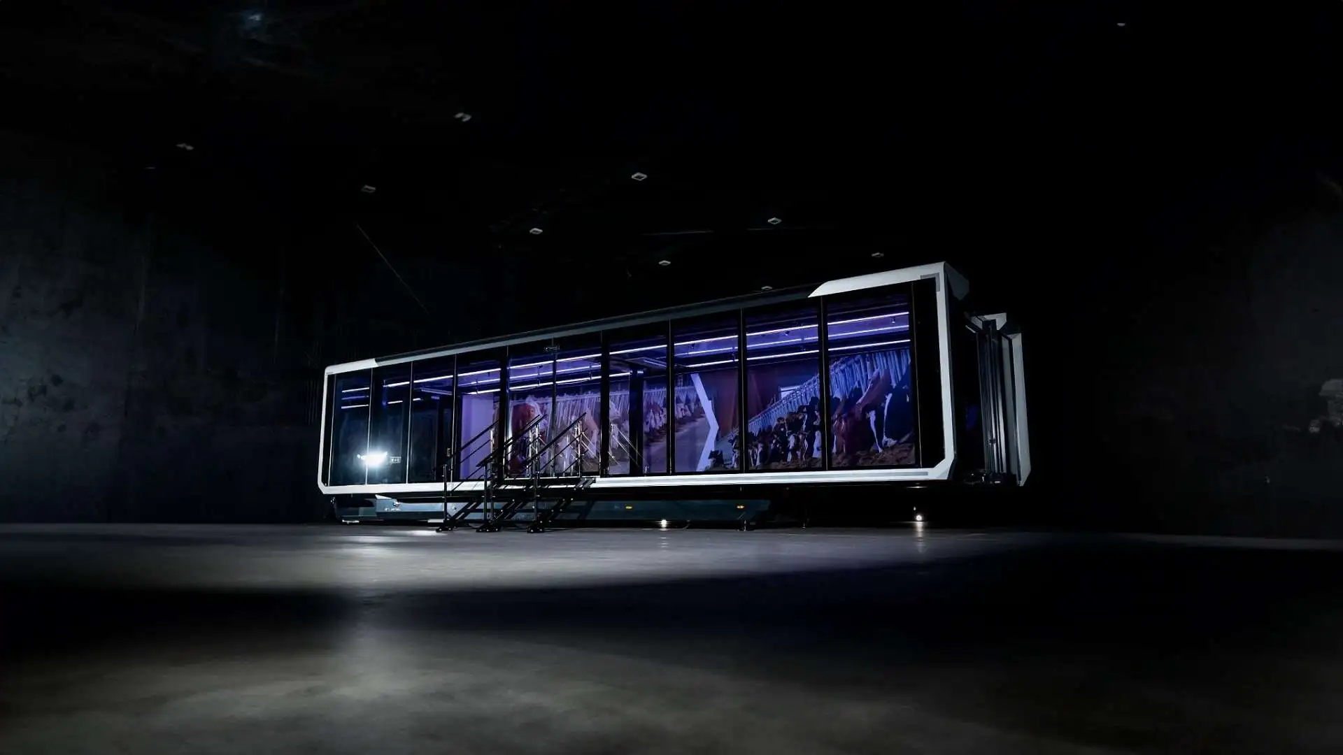 An Expandable Trailer in a dark, industrial environment, with a spotlight highlighting the unit against the dark backdrop.