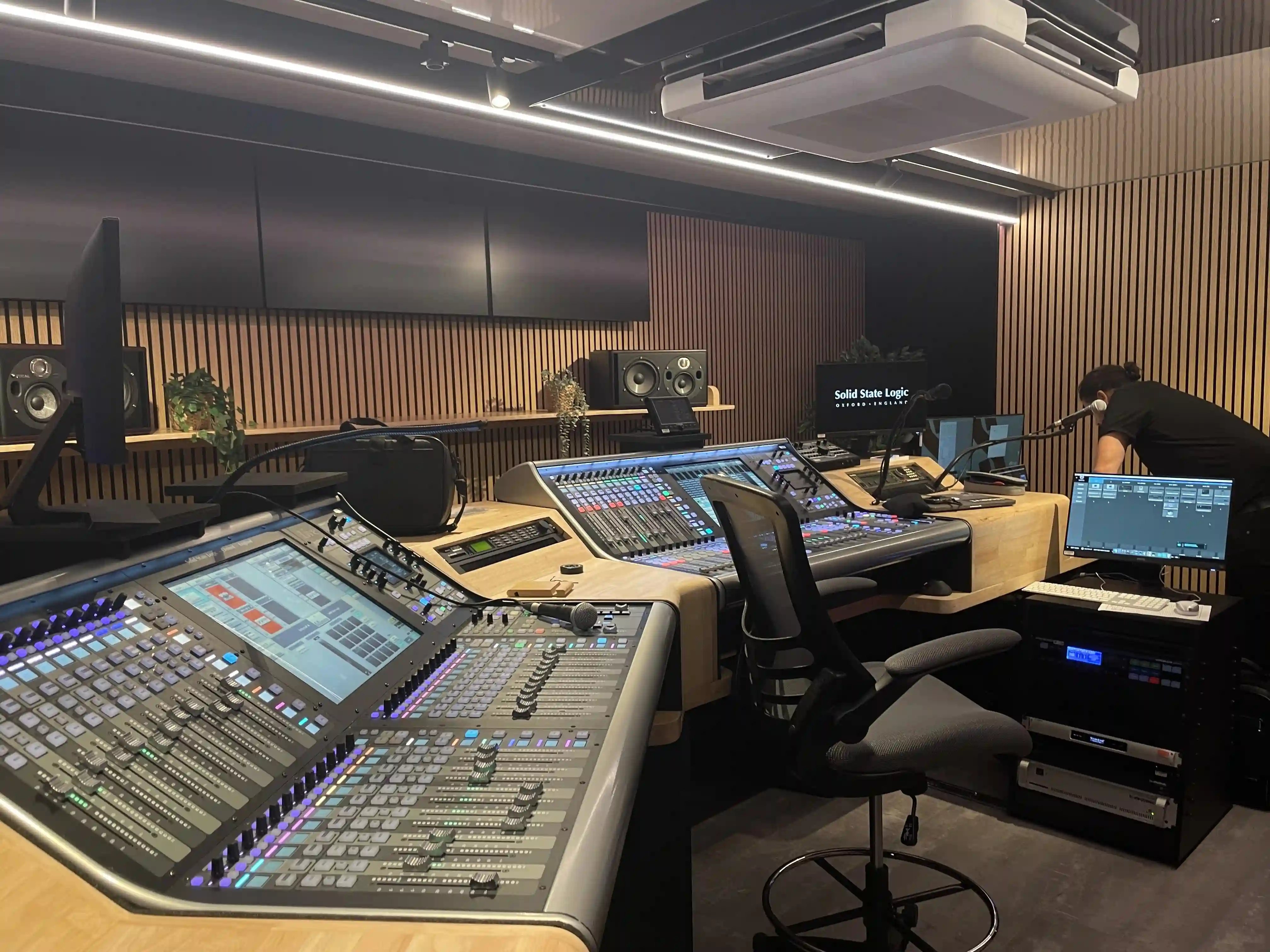 Interior of an Expandable trailer converted into a state-of-the-art audio mixing studio, featuring high-tech soundboards, monitors, and acoustic treatments.