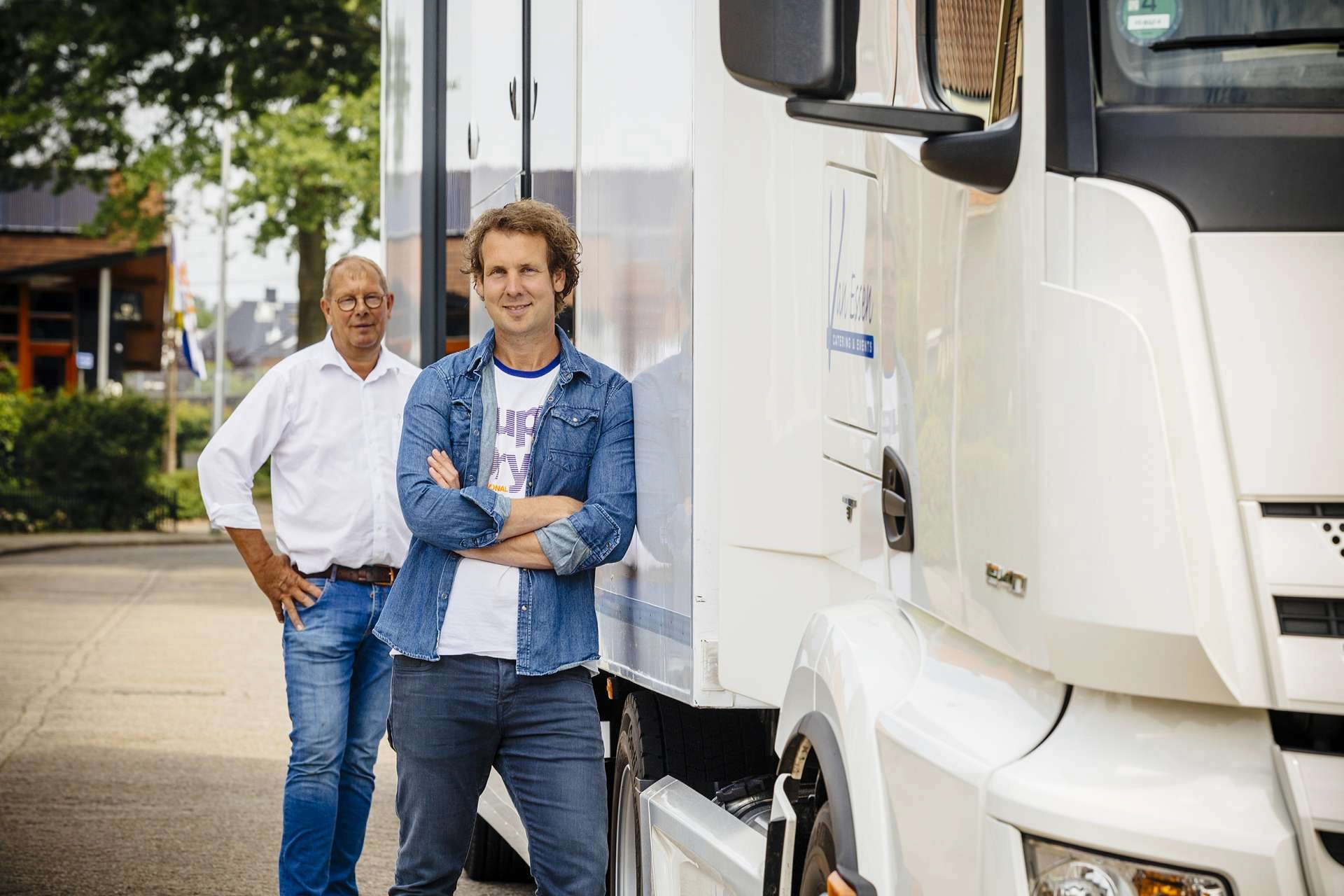 Paul van Essen and colleague posing confidently beside their Expandable catering trailer, ready to deliver exceptional event services.