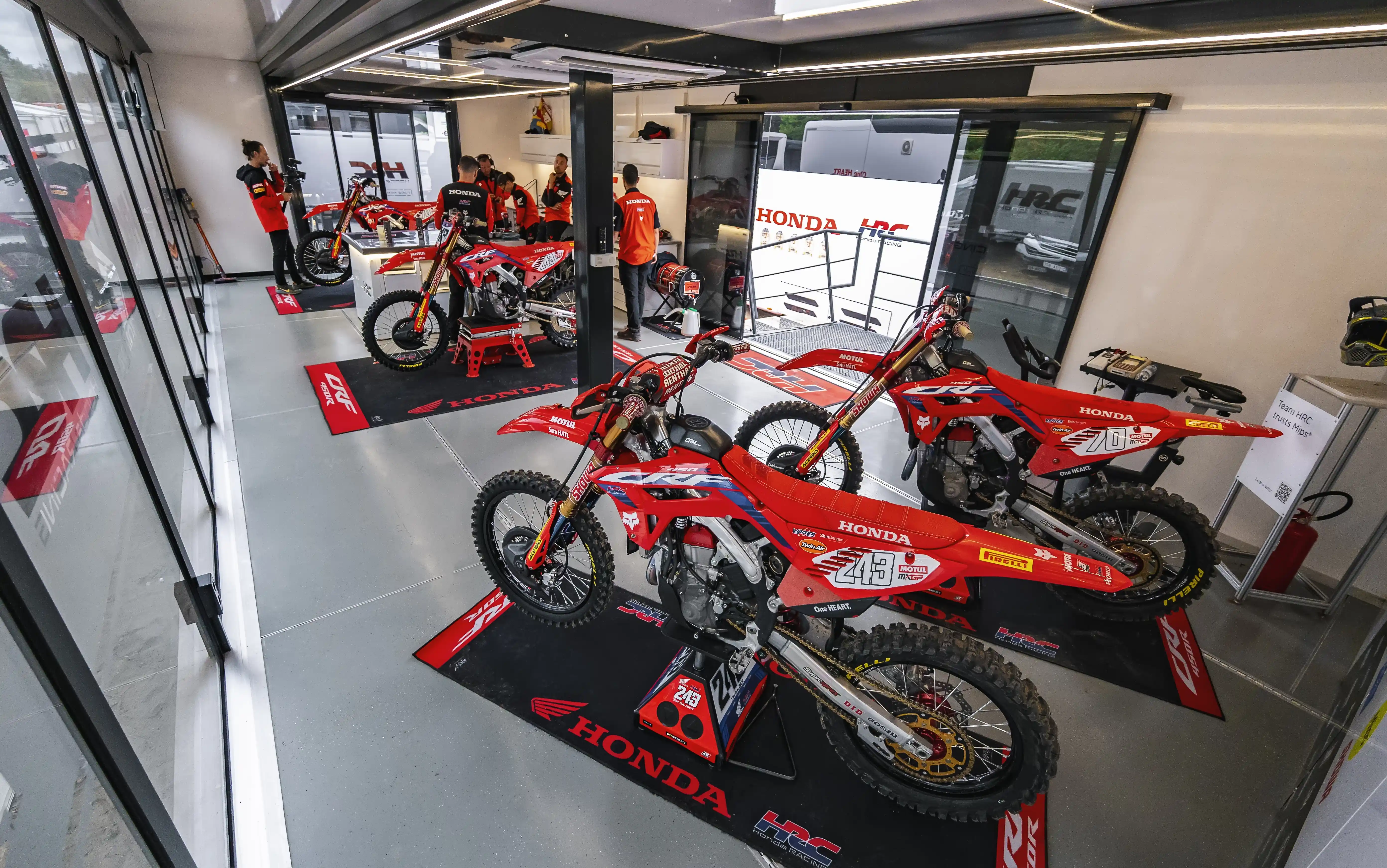 Inside the sports trailer, Honda motocross bikes are on display, with team branding throughout the well-lit, spacious interior.