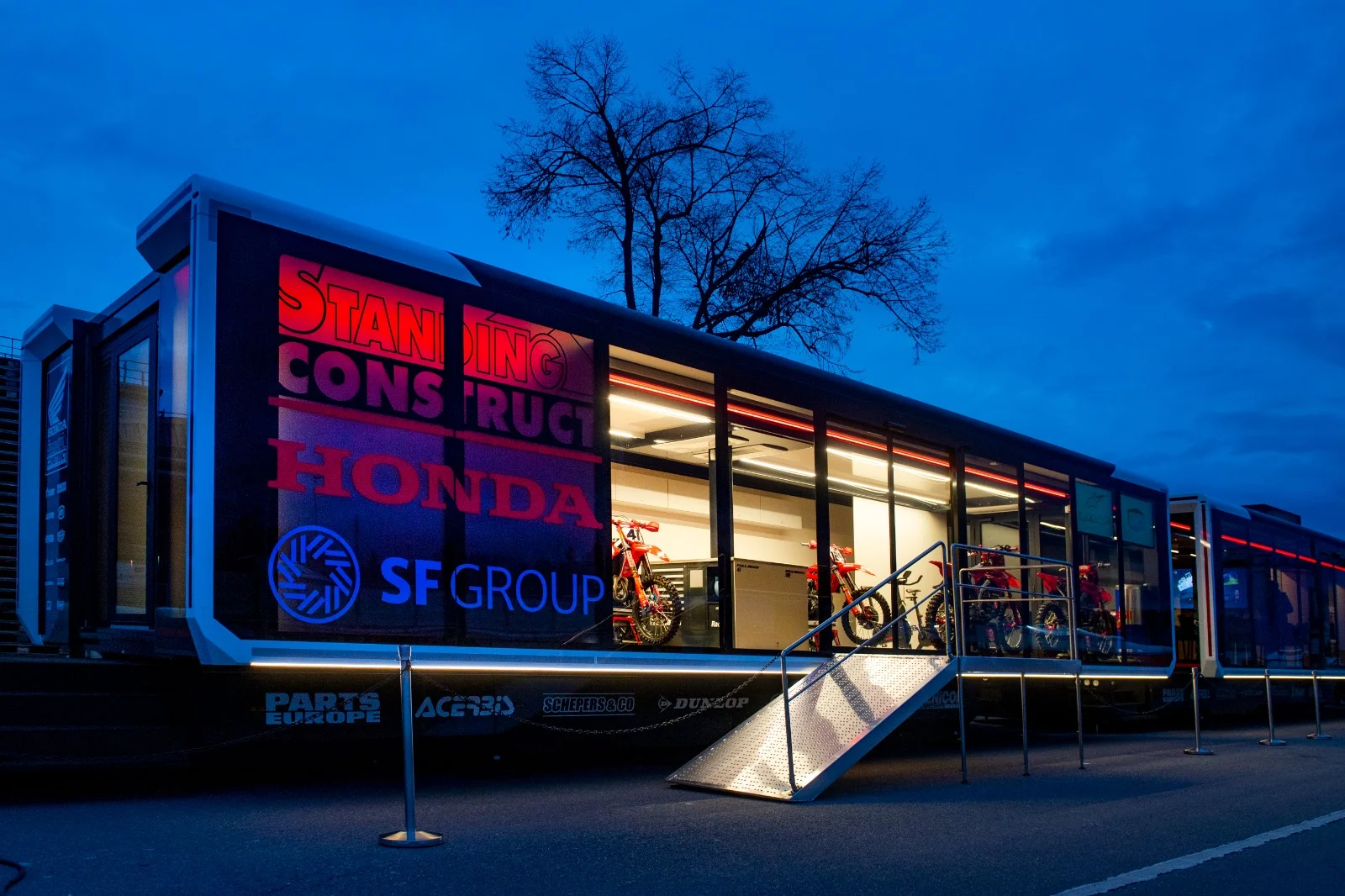 An Expandable Motorcycle Trailer with Honda branding and red motorcycles inside