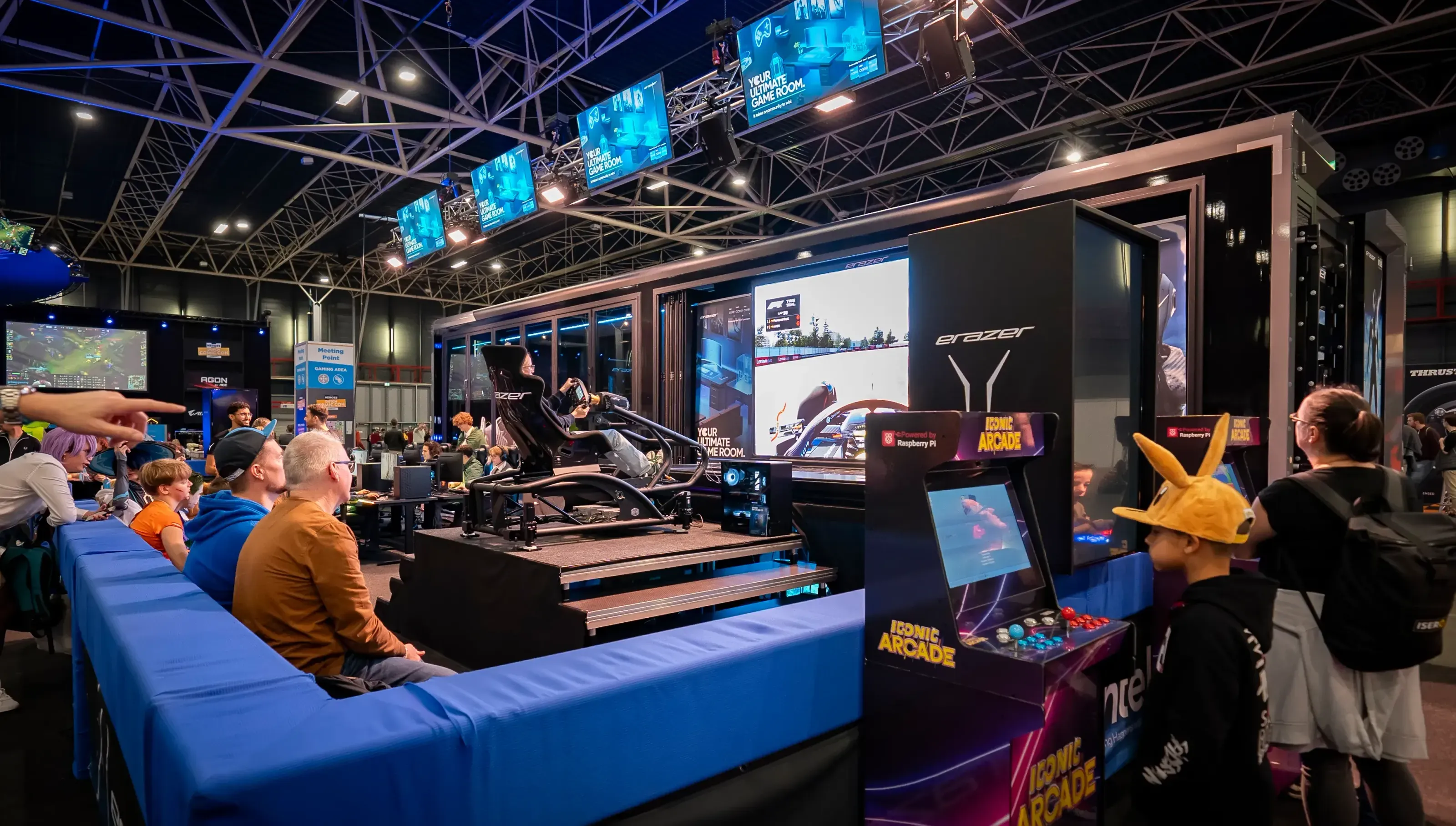 Tráiler de juego ampliable en una exposición, con simuladores de carreras y juegos de arcade.