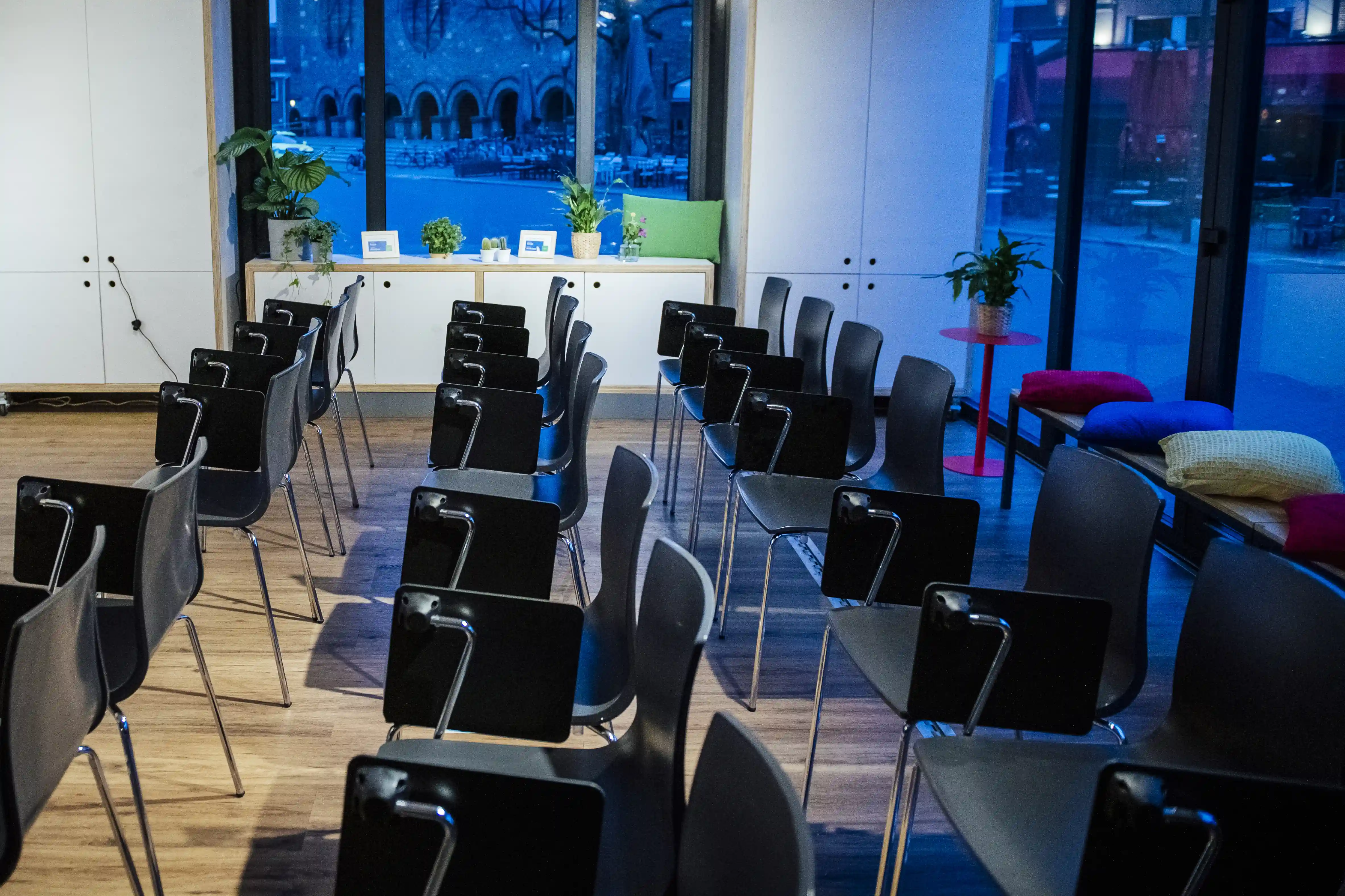 Vista interior de una oficina doméstica móvil, con hileras de sillas frente a una pantalla de presentación, listas para un seminario o taller de negocios