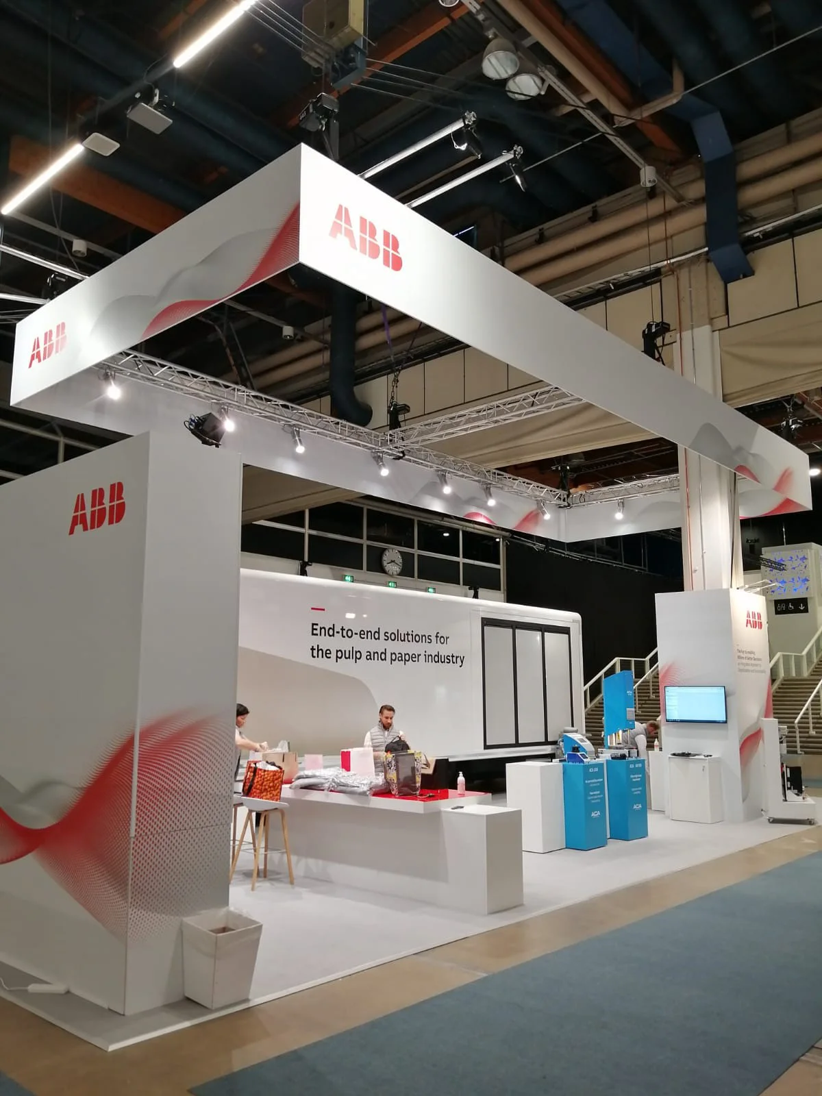 El interior de un camión itinerante de ABB se desplegó en un espacioso stand de exhibición desplegable, con un diseño minimalista con el logotipo de ABB en un lugar destacado. 