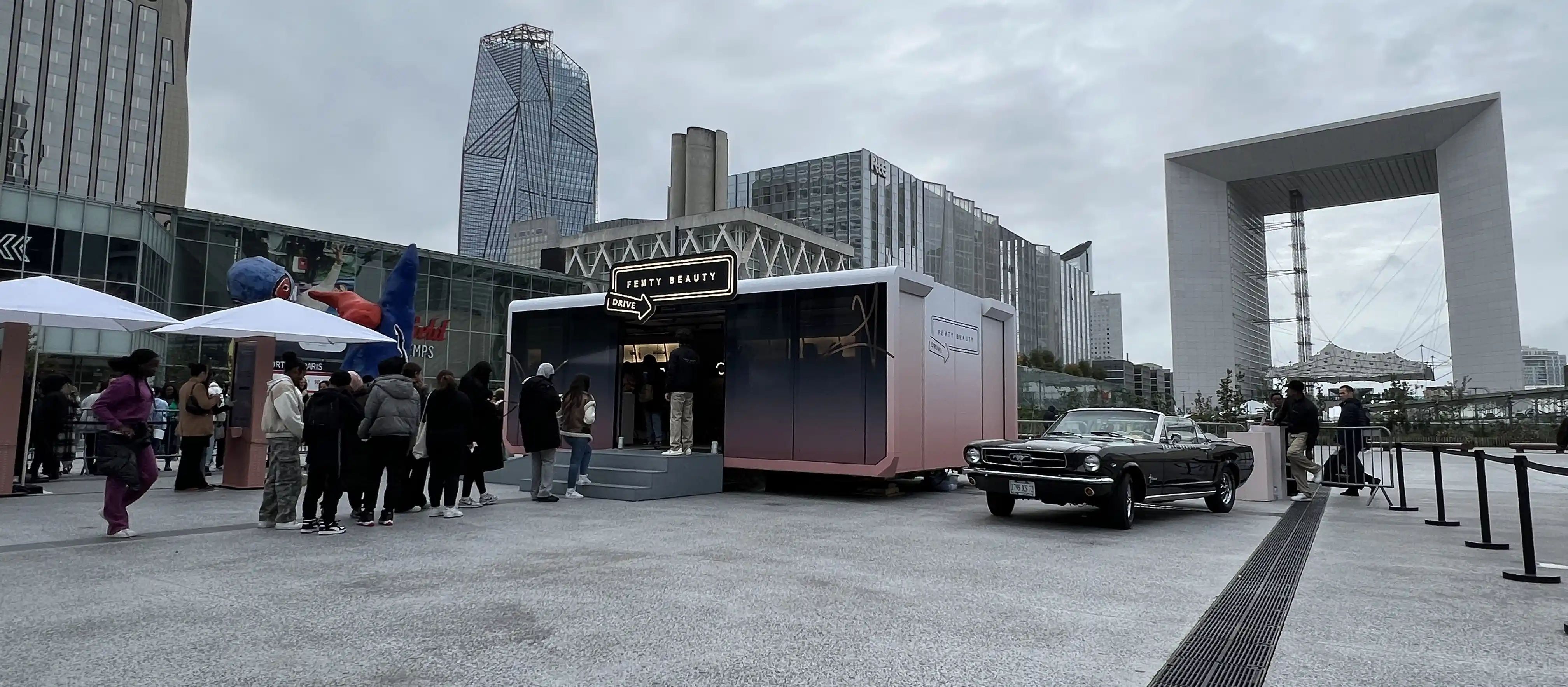 The exterior of a Fenty Beauty experiential marketing trailer, placed in an urban setting, inviting visitors to engage with the brand in a unique, mobile venue.