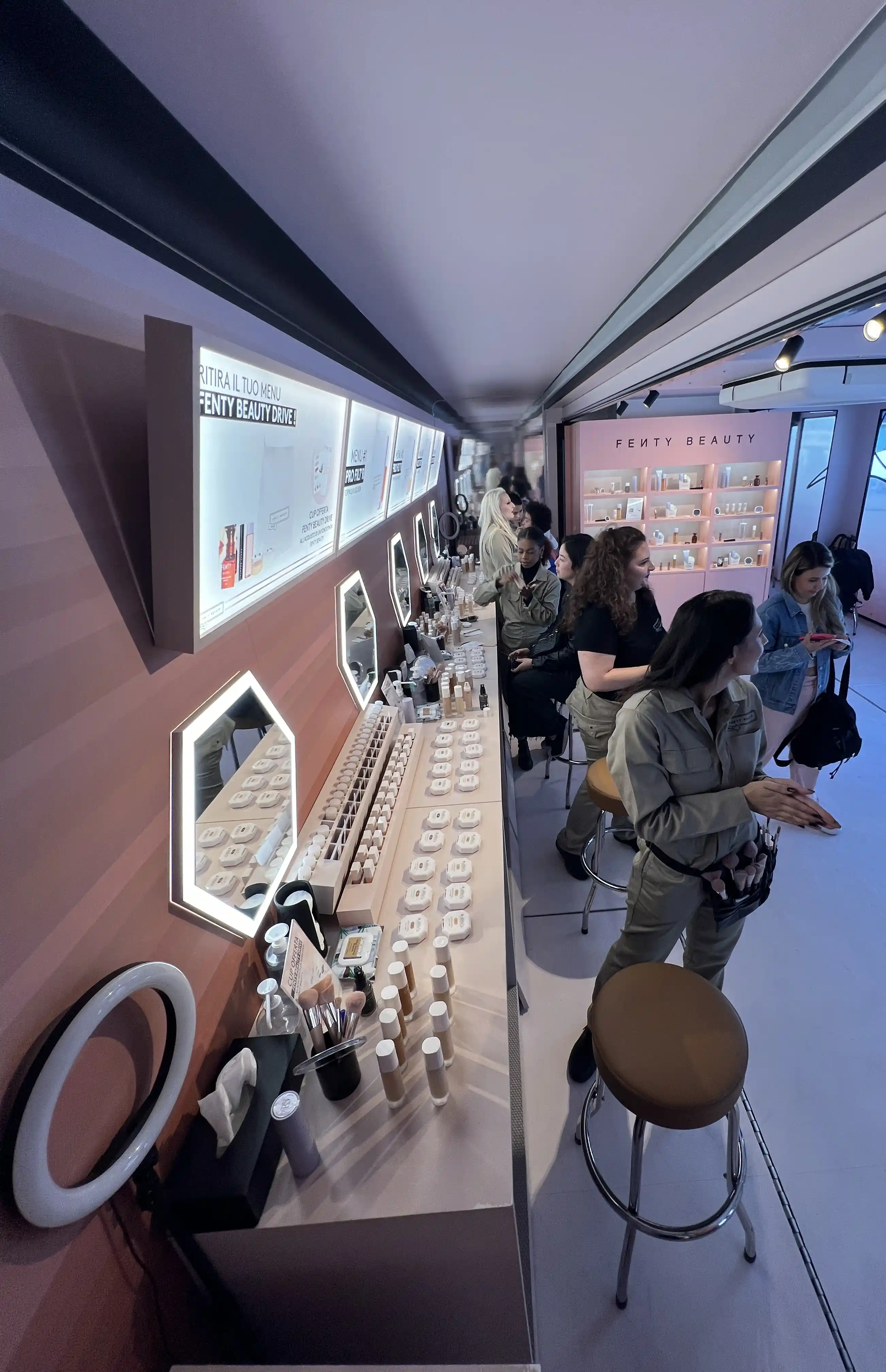 Dentro de un tráiler de marketing experiencial que presenta una configuración de Fenty Beauty con una variedad de productos de maquillaje, espejos y asientos para las pruebas con clientes