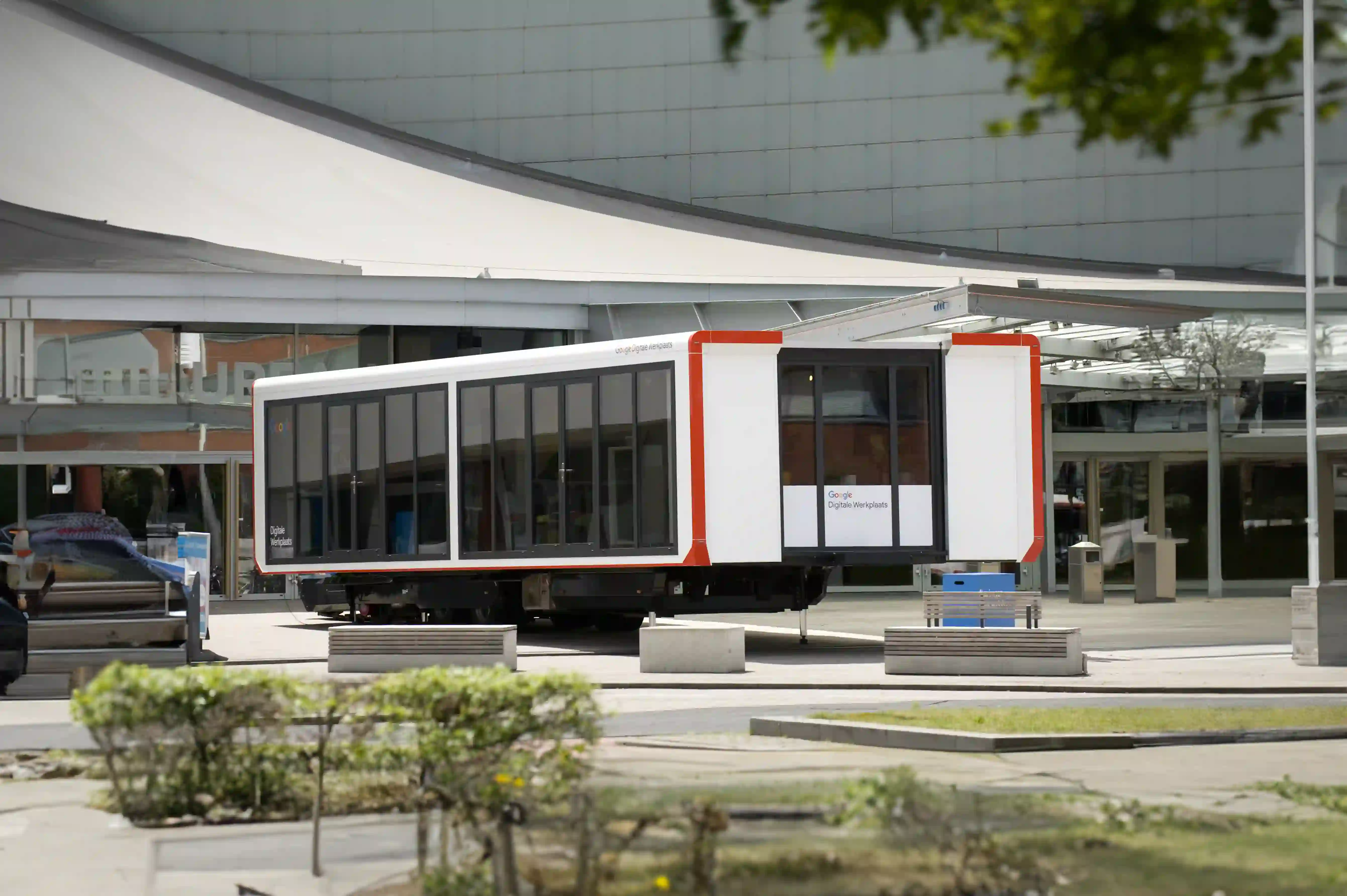 A commercial trailer parked outdoors with 'Google Digitale Werkplaats' branding, part of a commercial event or learning workshop.