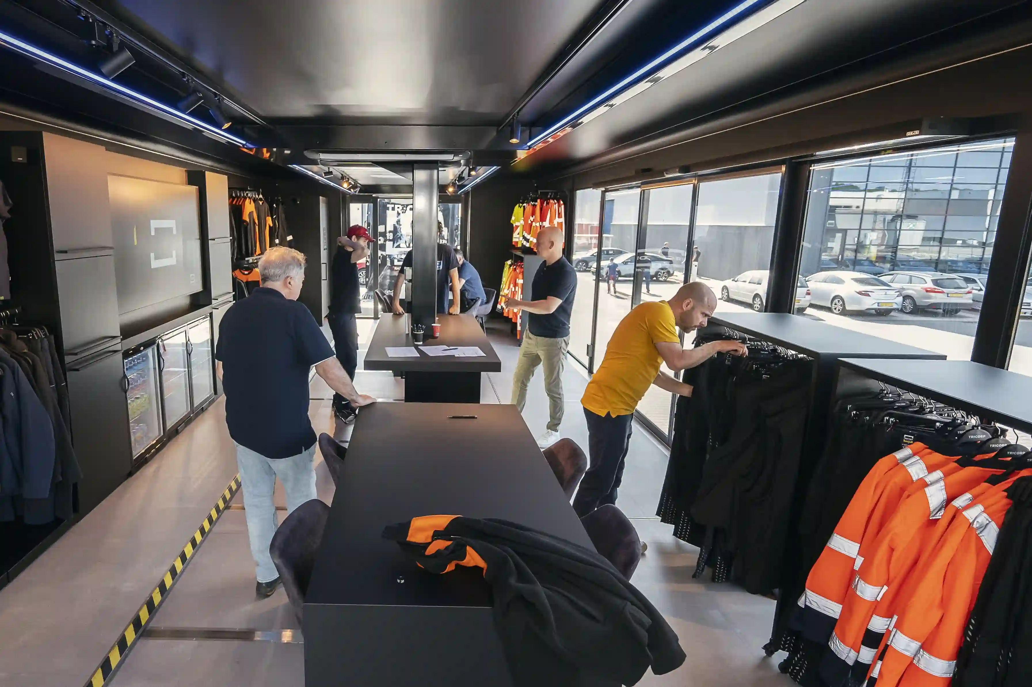 Interior of a mobile fitting room with well-organized clothing racks and a spacious changing area, highlighting functionality and modern design.
