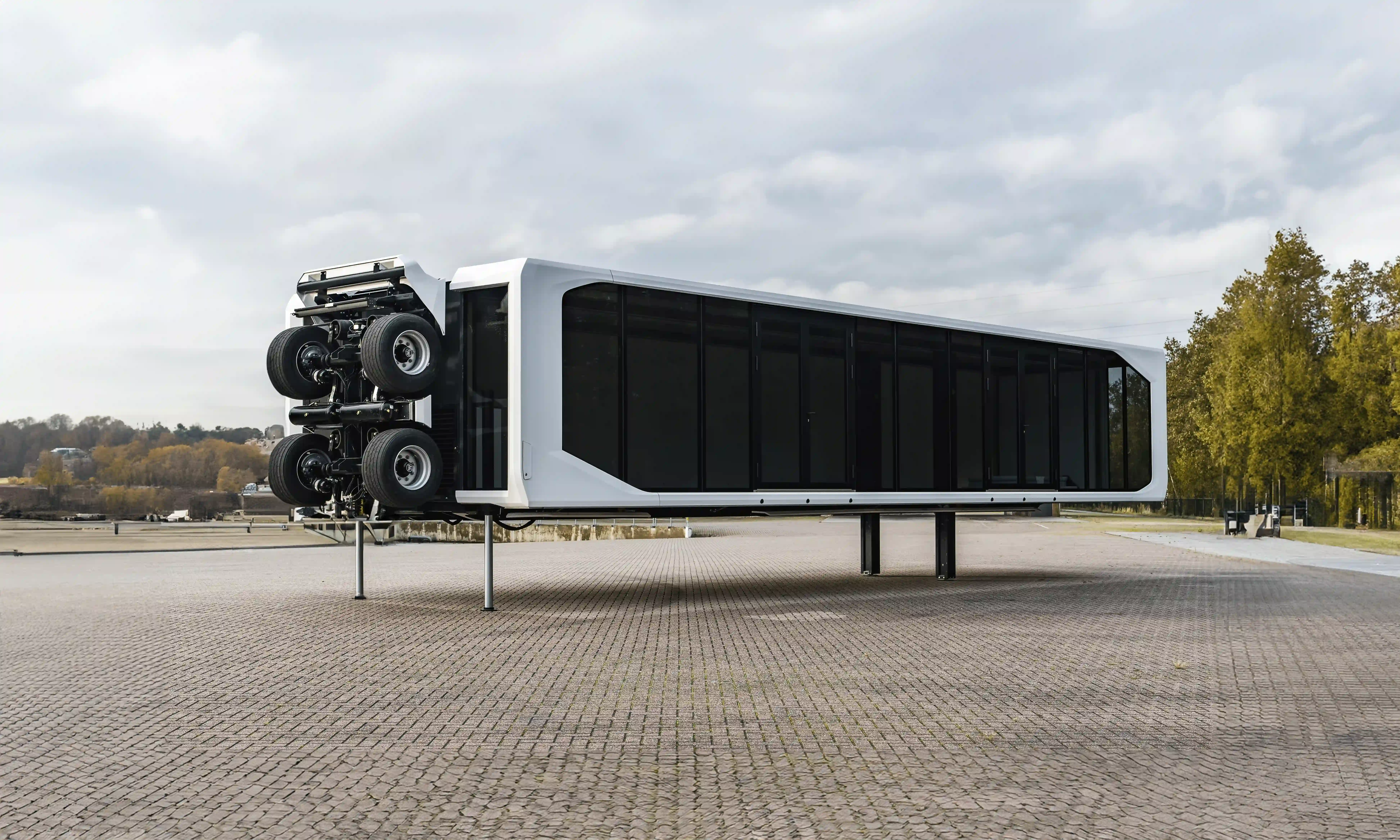 An aerial view of an expandable touchdown trailer in a tipped-over position on a brick-paved lot.