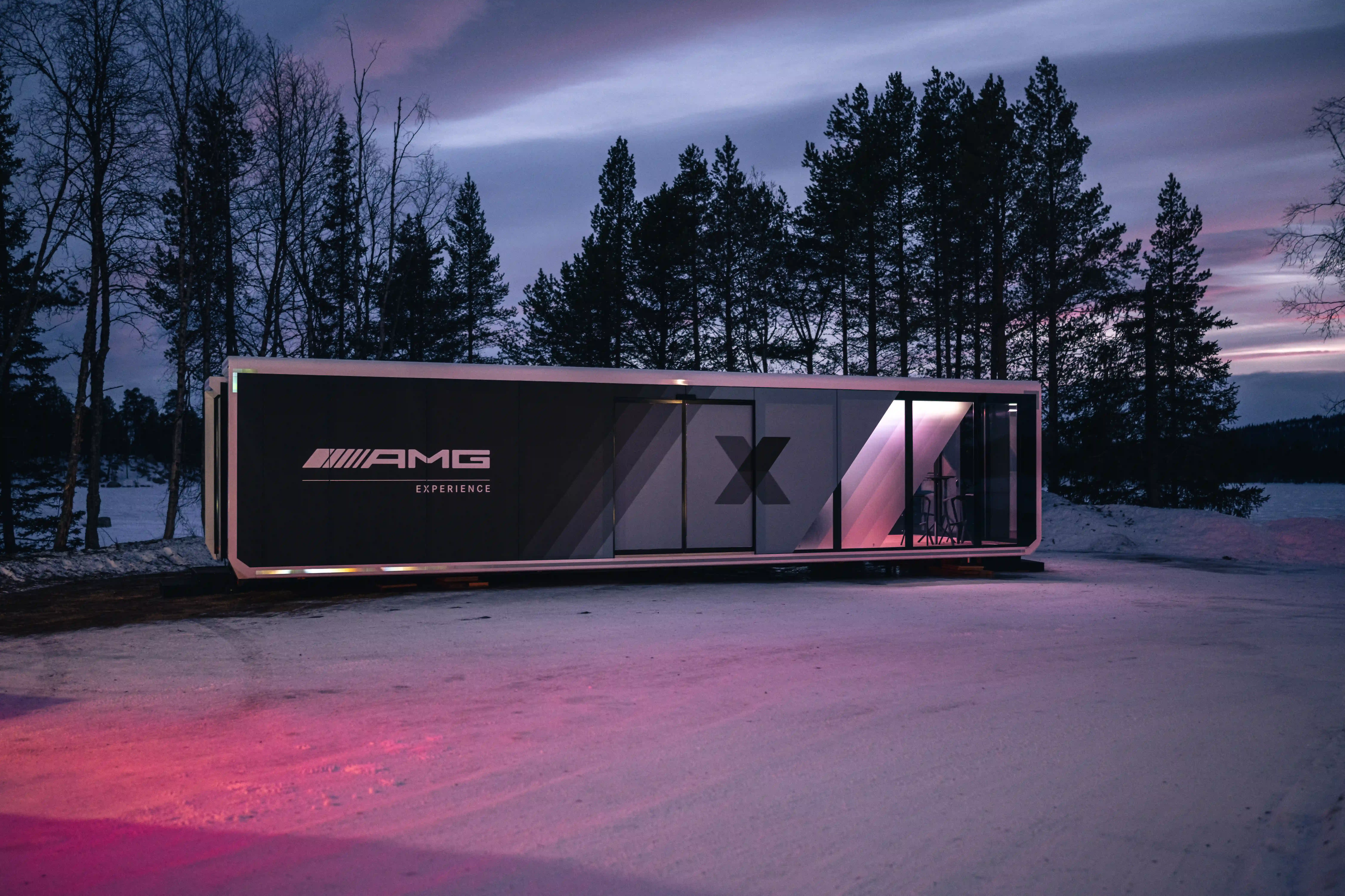 Expandable's high-tech mobile experience pod with AMG branding illuminated in twilight.