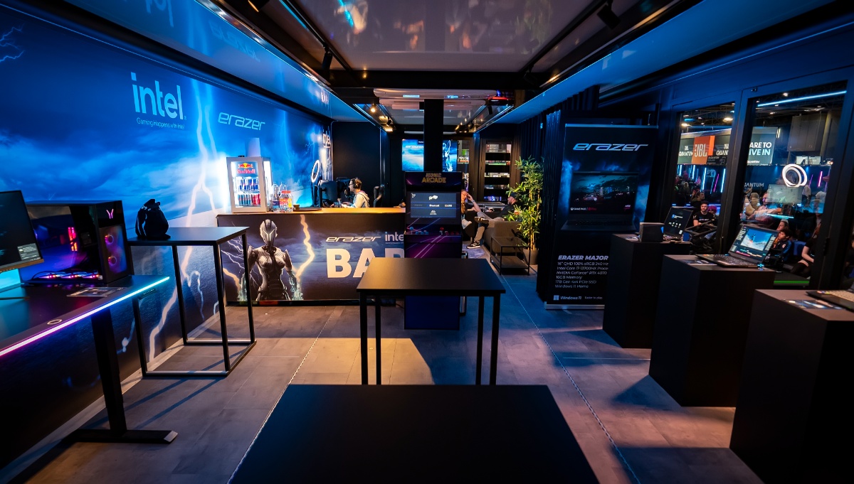 Inside a modern gaming trailer with blue LED lighting, showcasing the latest in gaming technology. The space is optimized for interaction, with gaming stations set against branded backdrops, inviting an immersive experience for players and visitors.