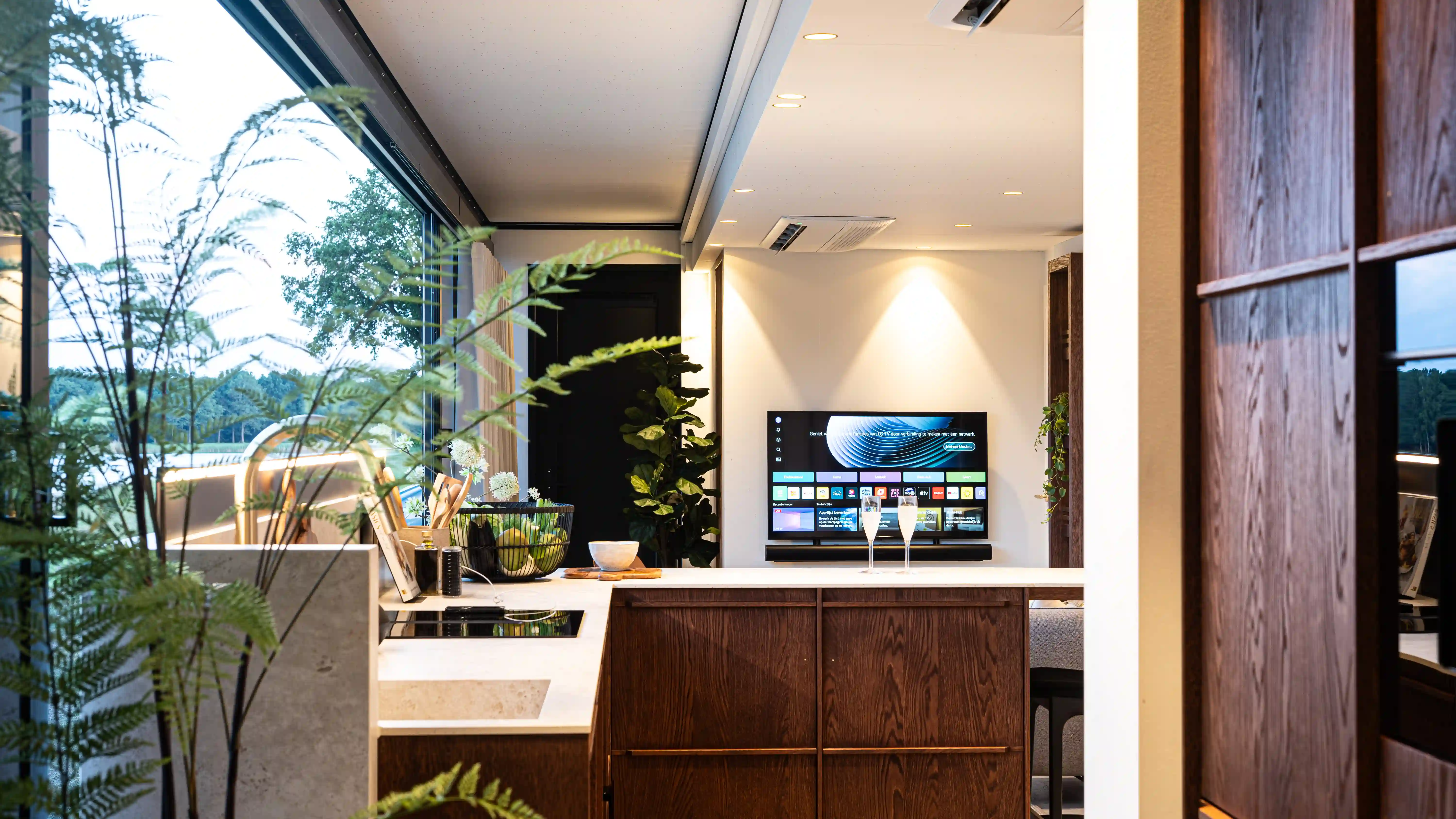 Vista interior de una lujosa mansión ampliable que cuenta con una elegante cocina con electrodomésticos modernos, una espaciosa encimera y elegantes gabinetes de madera.