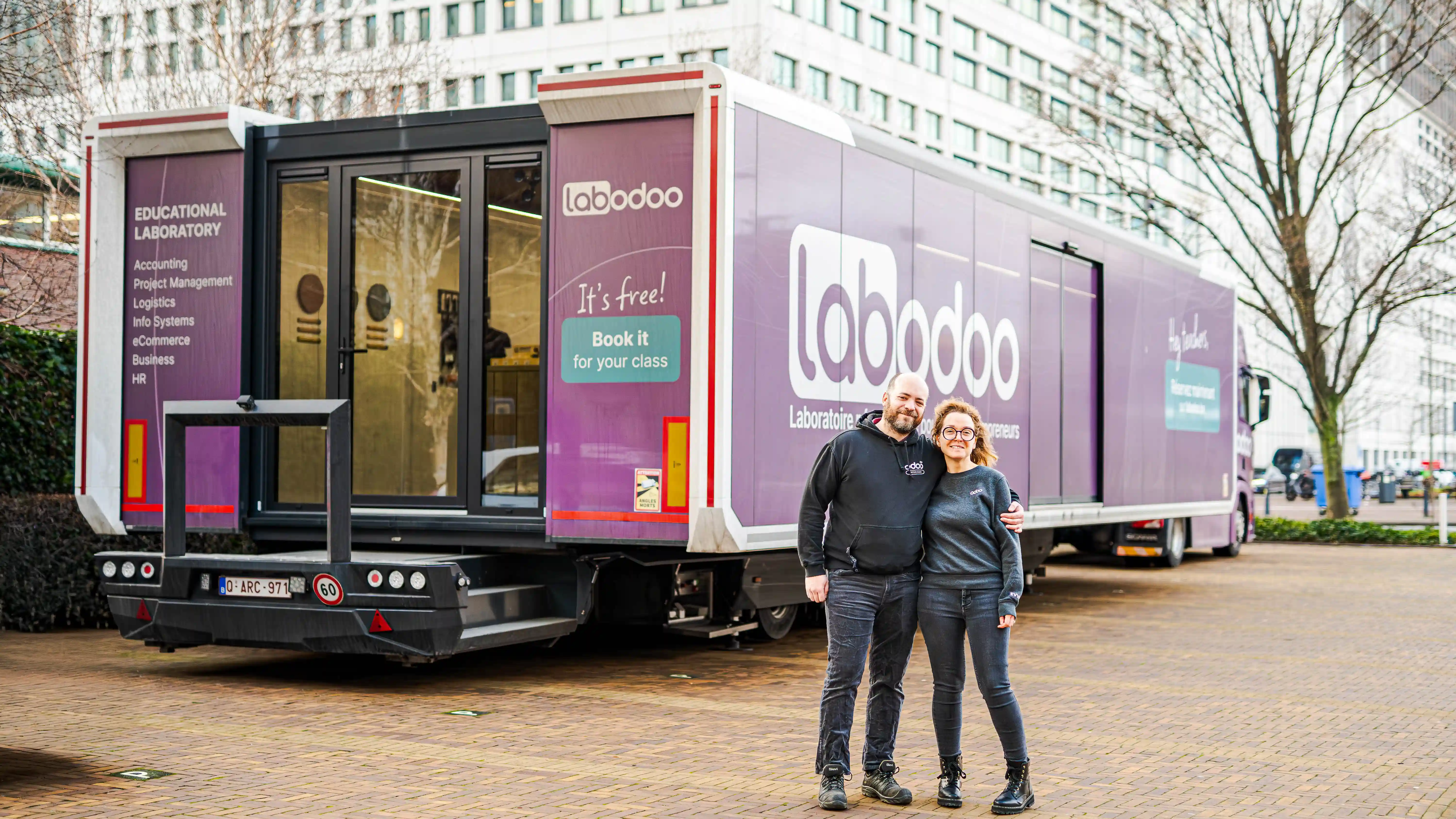 Odoo's LabOdoo educational trailer parked, featuring vibrant purple branding and interactive learning modules. inviting students to a unique, hands-on ERP learning experience