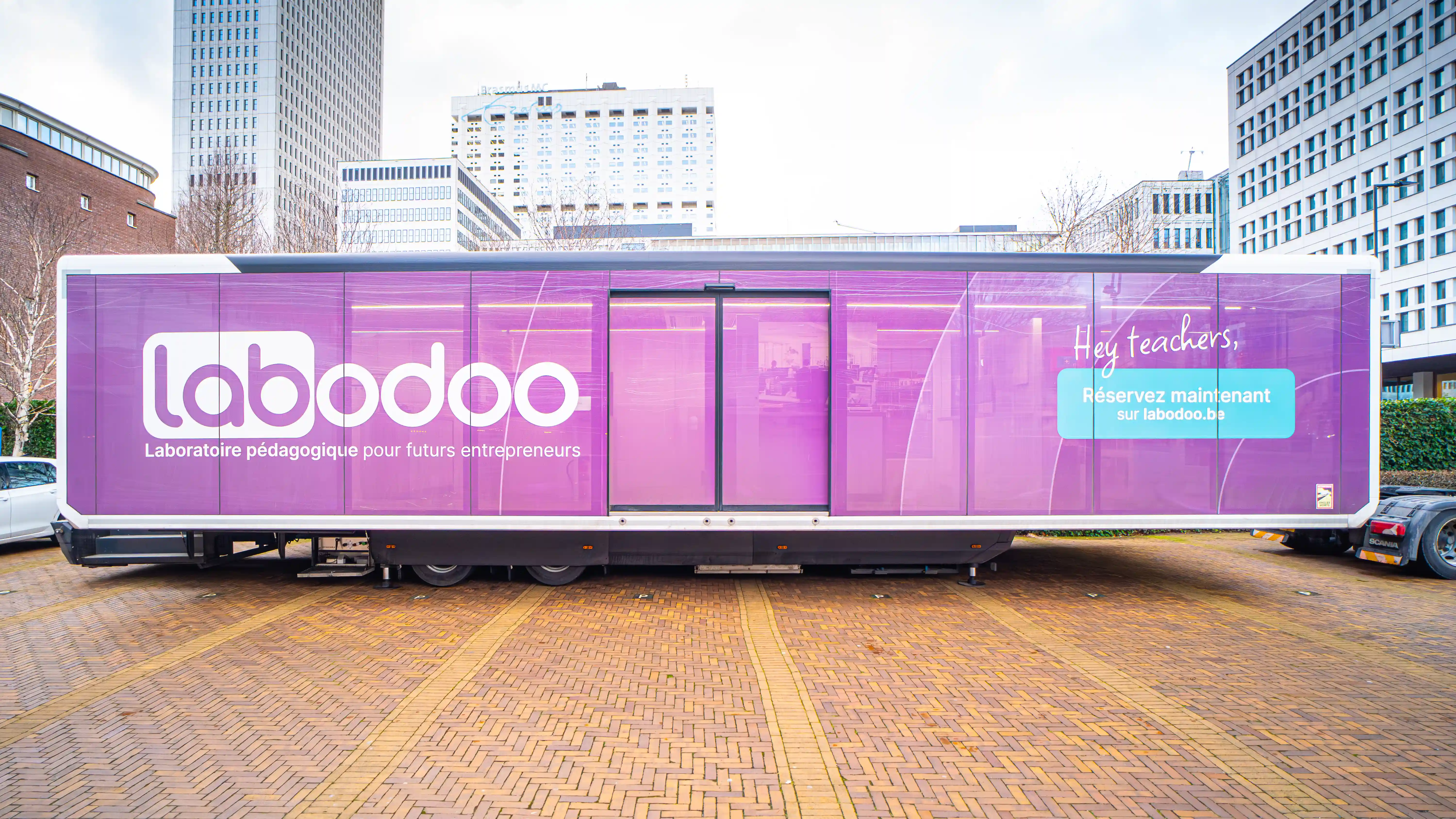 Frontansicht des erweiterbaren Labodoo-Trailers von Odoo mit offenen Türen, der die Schüler zu einer einzigartigen, praktischen ERP-Lernerfahrung einlädt