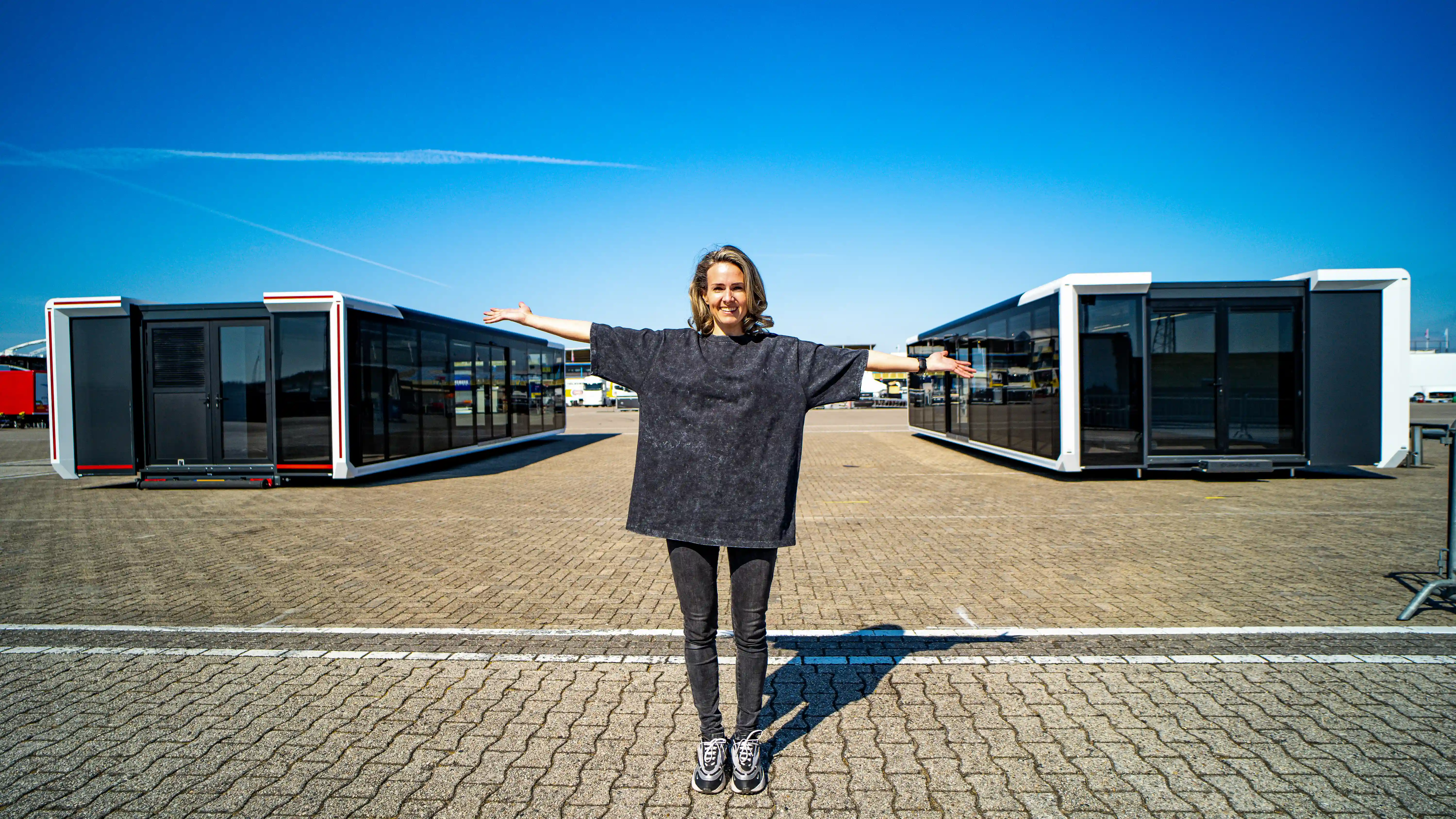 Expandable trailer setup at TT Circuit in Assen, surrounded by colorful tulips and palm trees, providing a comfortable hospitality environment for Glenn van Straalen's guests.