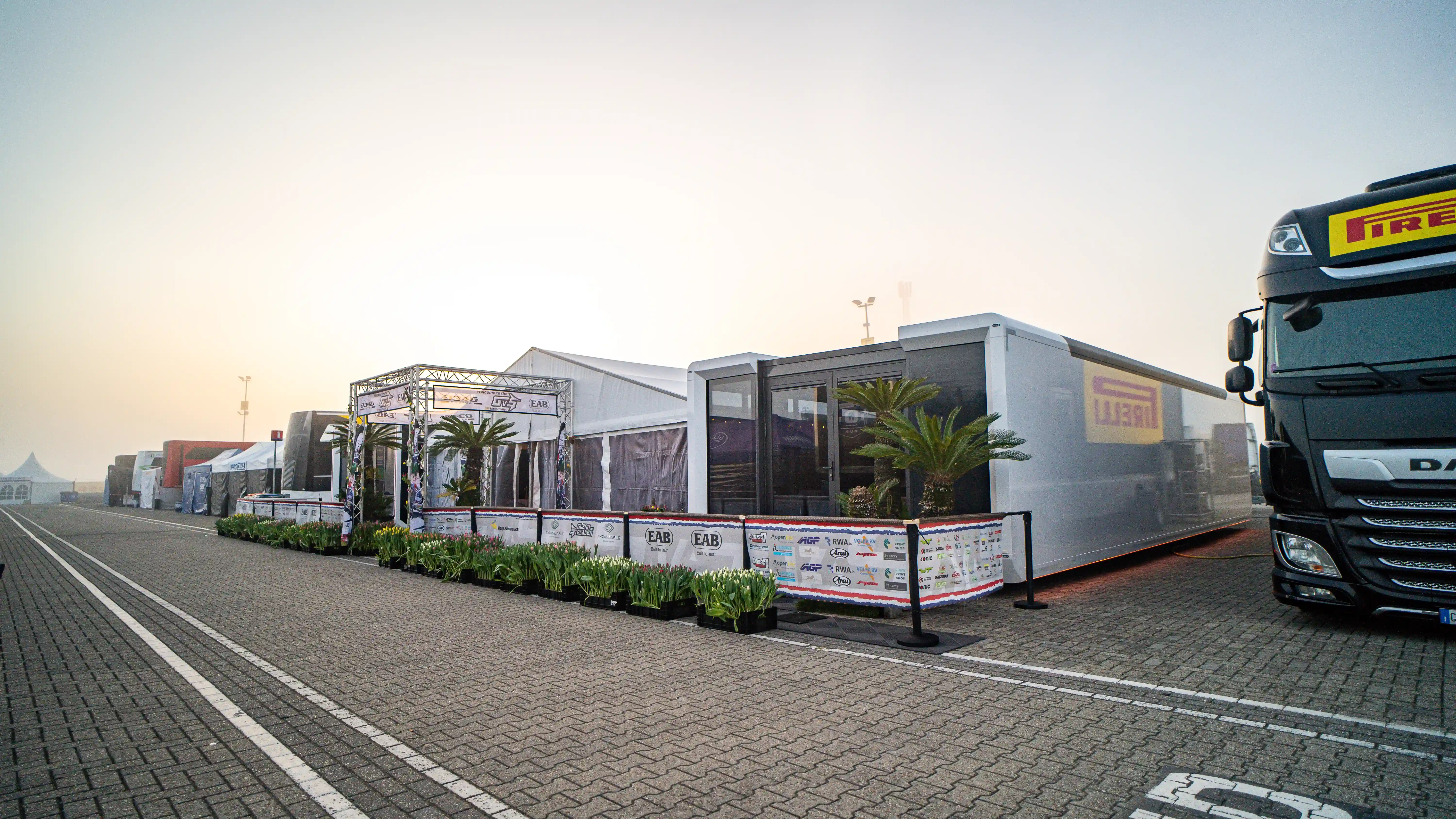 Expandable trailer setup at the TT Circuit in Assen, featuring tulip decorations and a truck, providing a comfortable and efficient hospitality environment for Glenn van Straalen's guests.