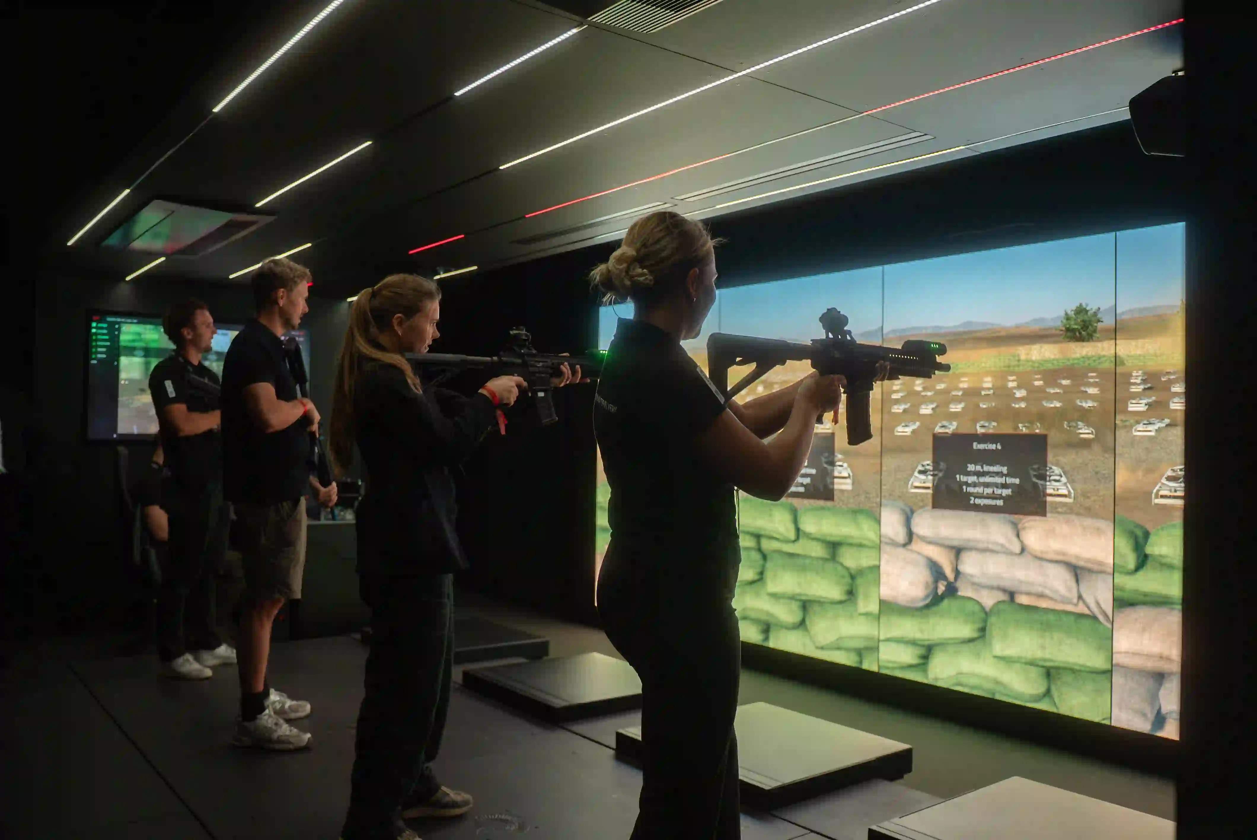 Interior of the Guardiaris Expandable Touchdown Unit, set up as a Mobile Training Center with immersive LED wall, rifles, and participants engaged in live shooting simulation exercises.