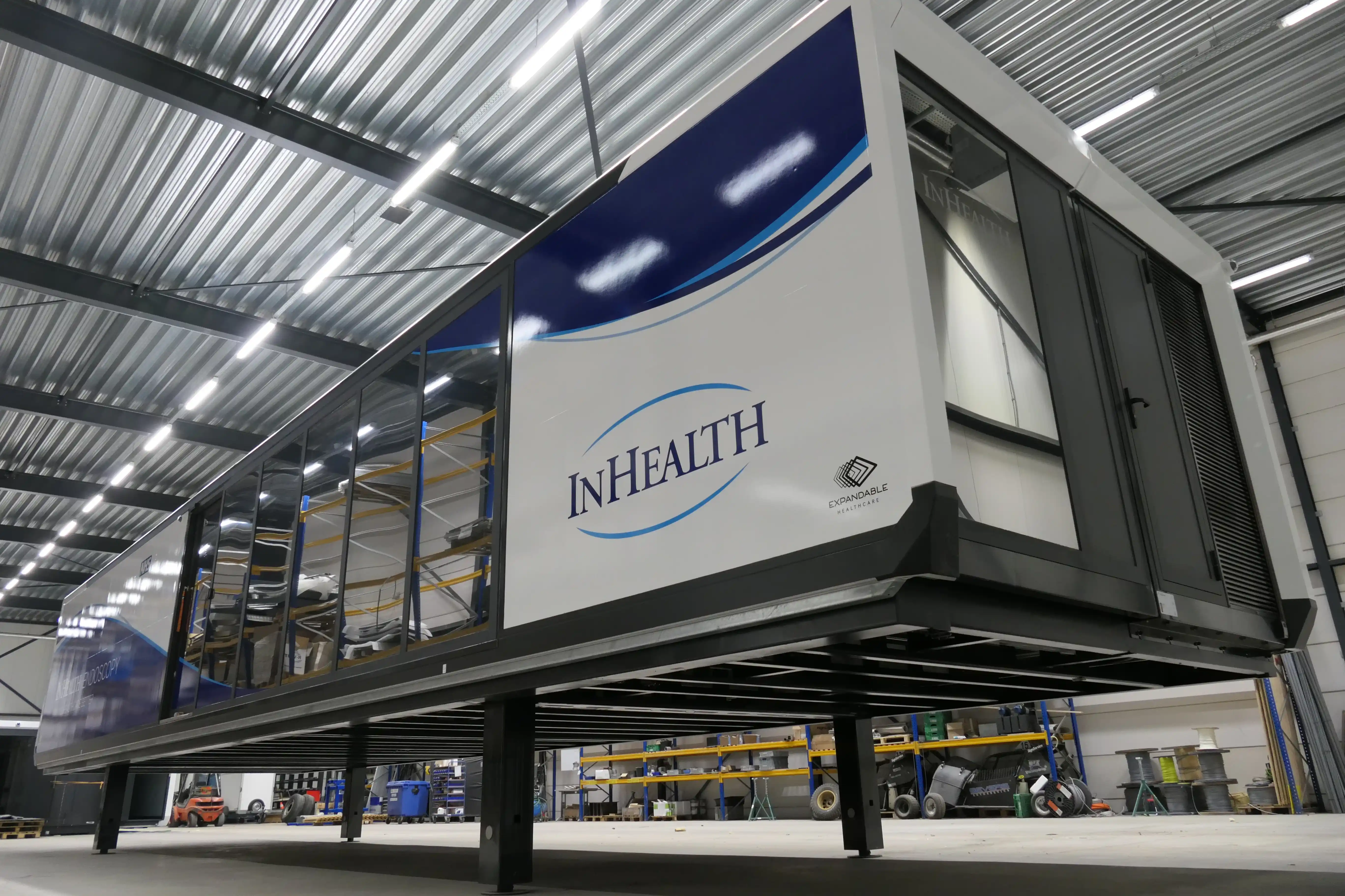A white mobile surgery unit truck parked on a paved lot under a clear sky, designed for quick deployment with all necessary surgery equipment for field operations.