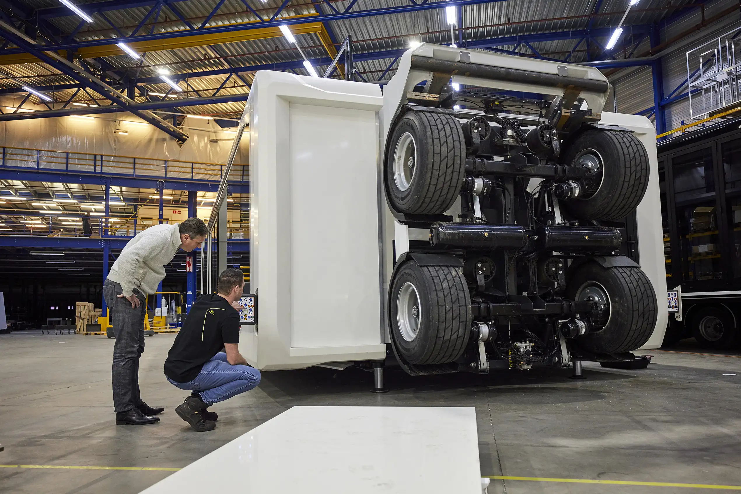 Quality inspection of an expandable unit during production, with engineers reviewing technical details on the assembly floor.